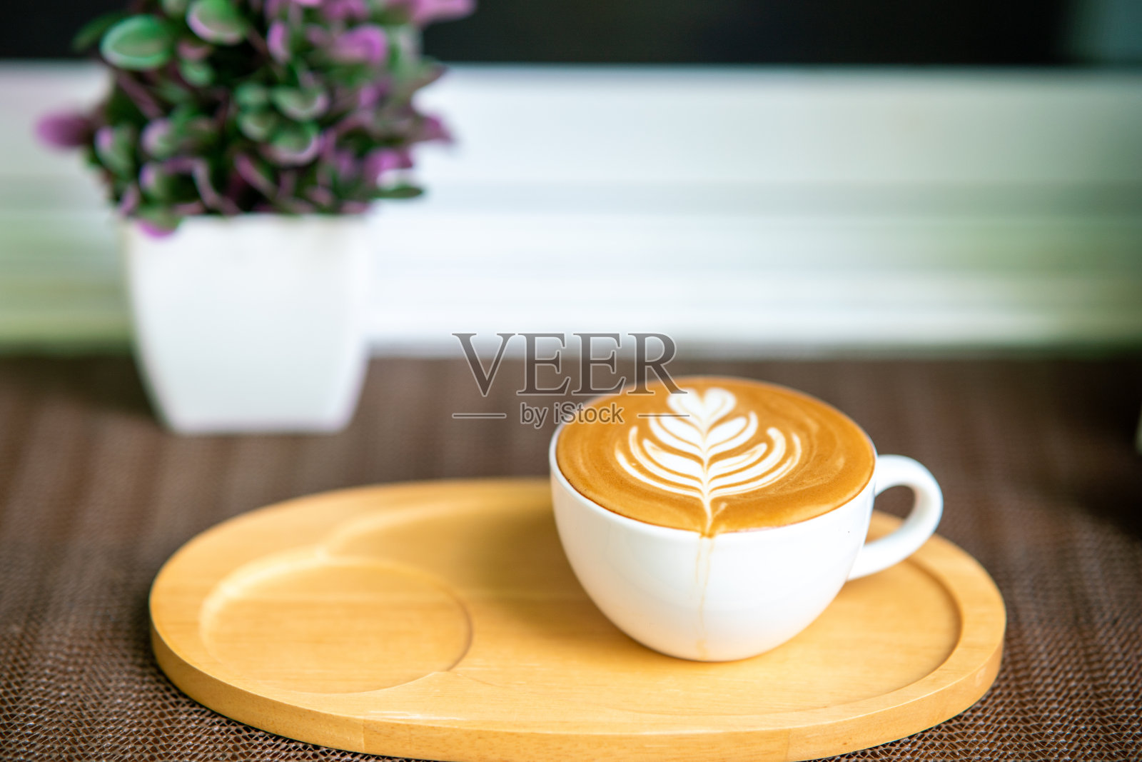 白色杯子里的咖啡图案放在木托盘上照片摄影图片