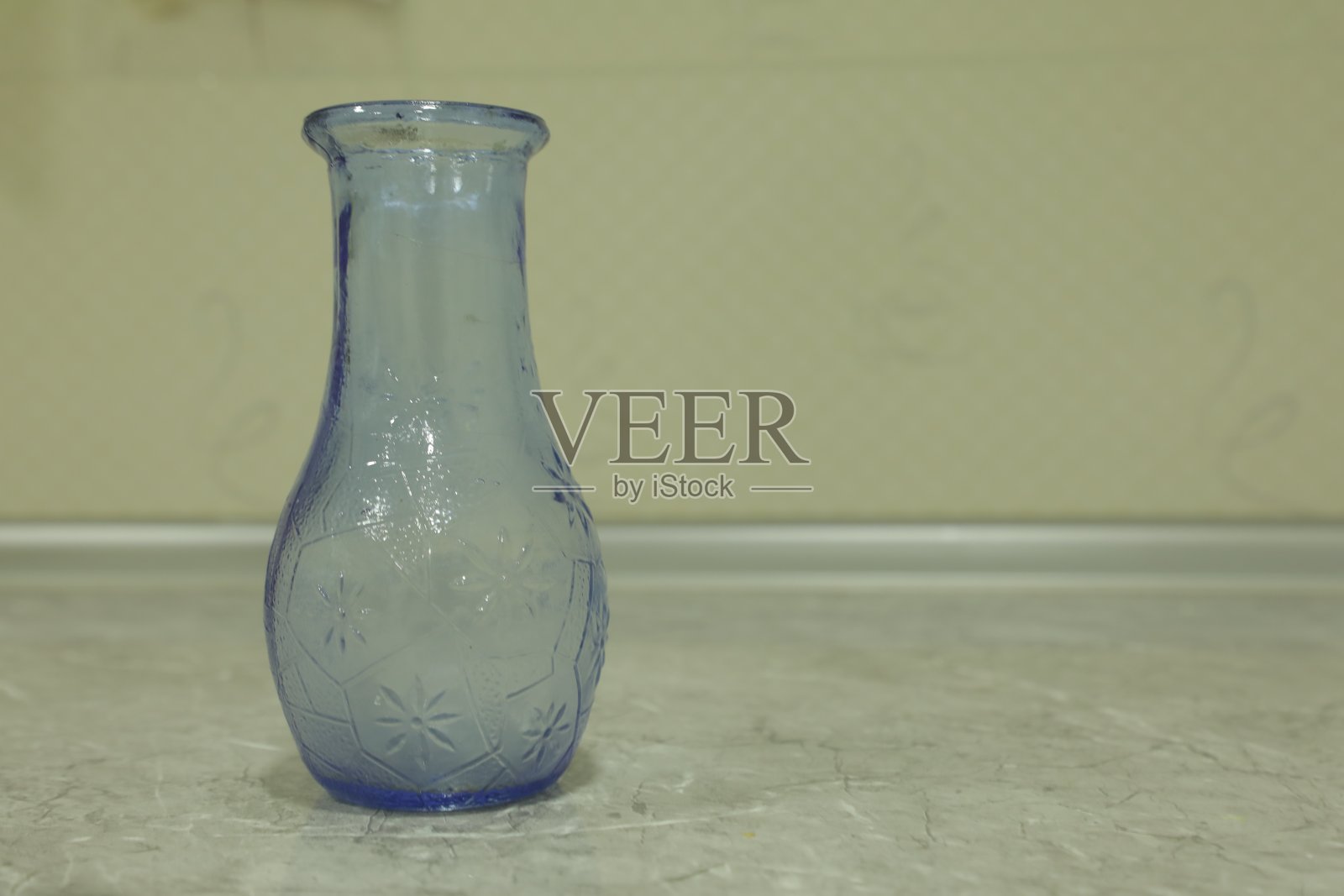 桌子上的空杯子和模糊的花瓶和花的背景。照片摄影图片