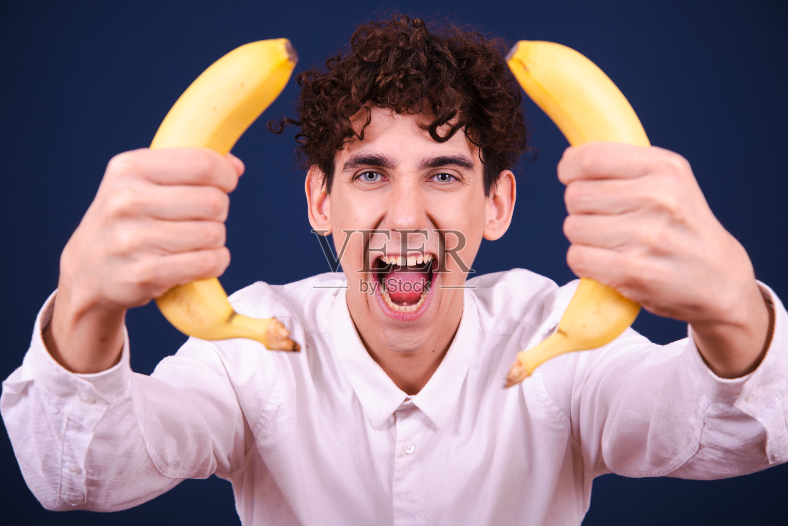 有趣的情绪化的家伙吃香蕉。照片摄影图片