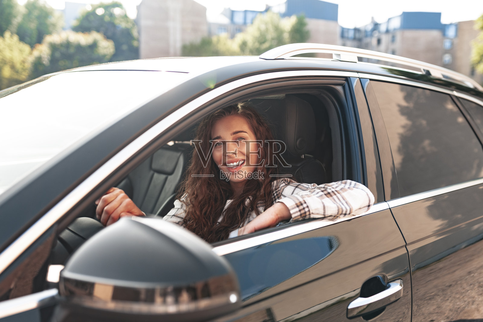 一个微笑着的年轻女子在城市里开车照片摄影图片