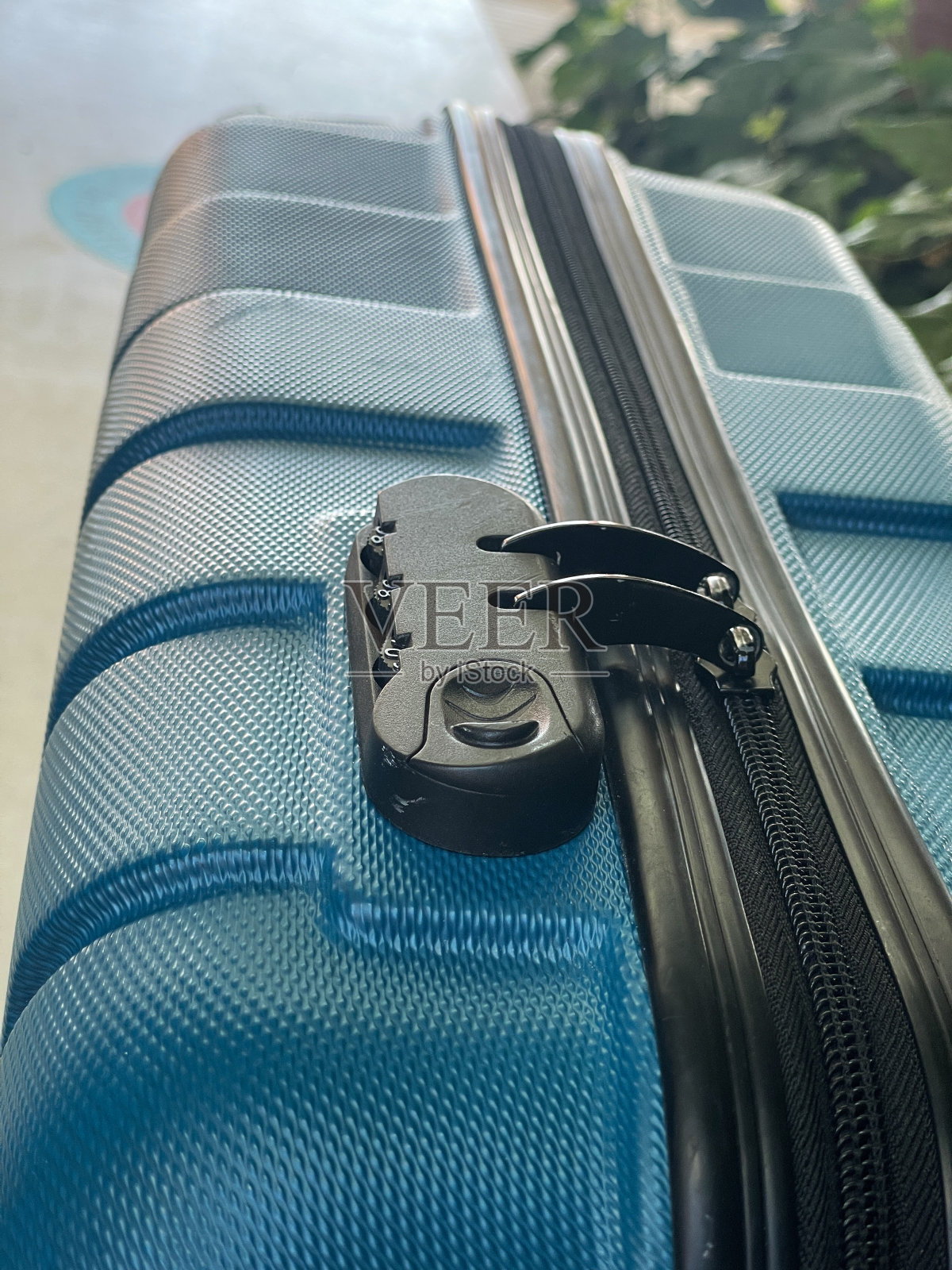 全画幅塑料图像,蓝绿色,机场值机区轮式行李,带拉链和组合密码锁的行李箱,高架视图,关注前景,旅行概念照片摄影图片