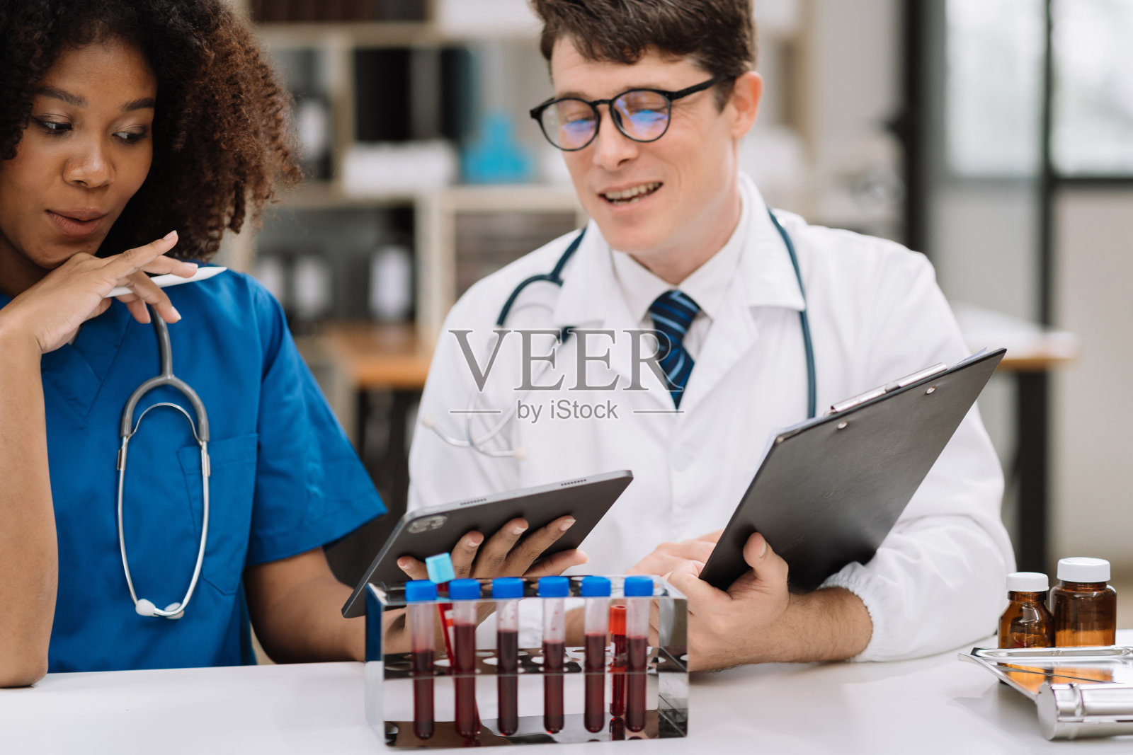 医疗团队在图表上分析患者的血液检查结果和药物使用情况,医疗检查的概念。照片摄影图片