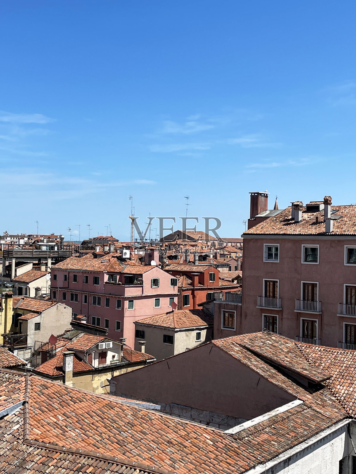 意大利威尼斯的城市景观,住宅建筑的赤陶土屋顶,湛蓝晴朗的天空,聚焦于前景照片摄影图片