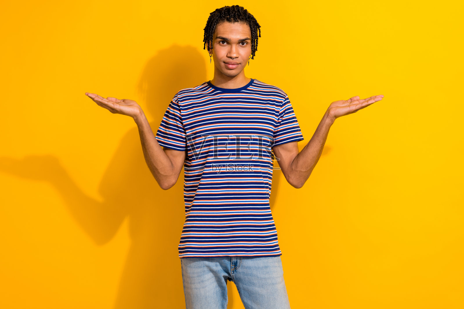 肖像自信的男人穿穿时尚的t恤手臂比较产品空空间孤立的黄色背景照片摄影图片