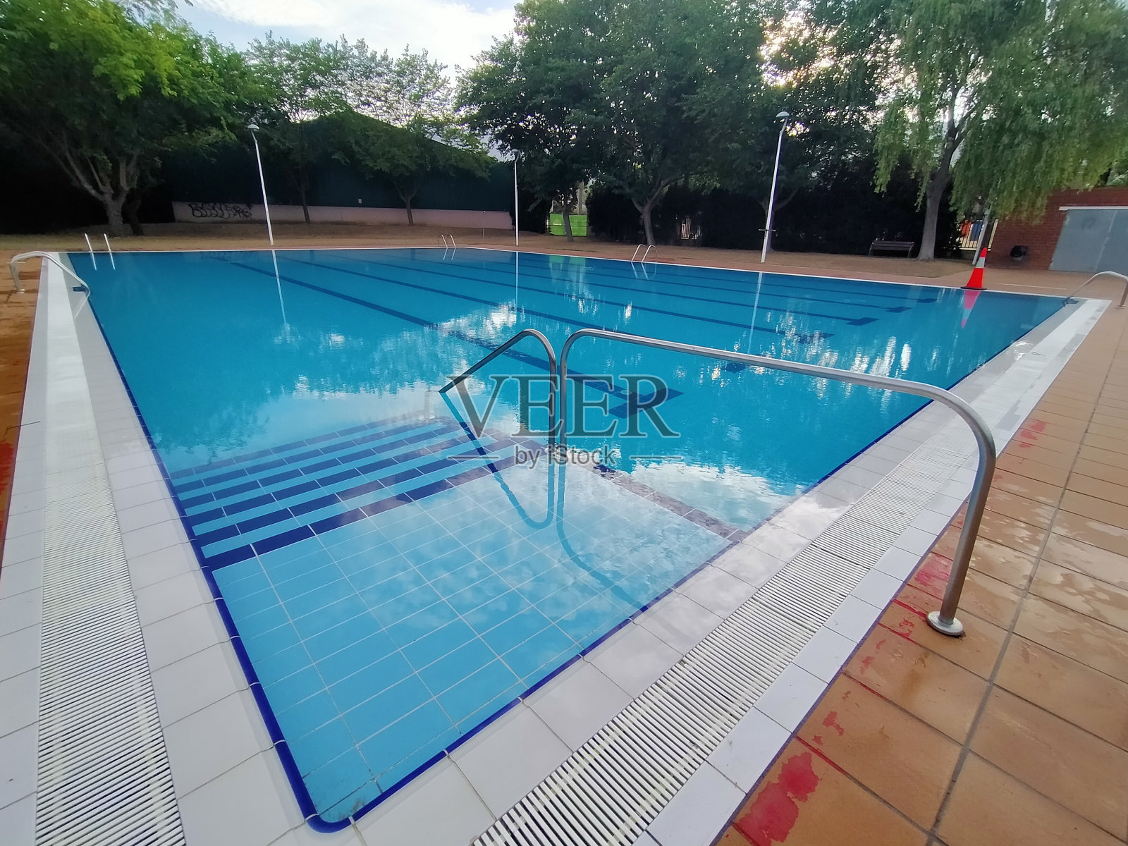 大型矩形游泳池(奥林匹克游泳池类型)对角线拍摄。背景是树木和蓝天白云照片摄影图片