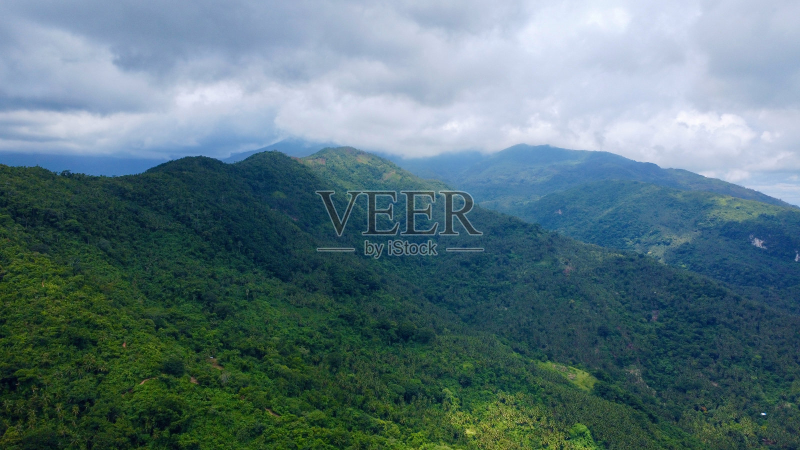 热带岛屿山峰上的雨云。照片摄影图片