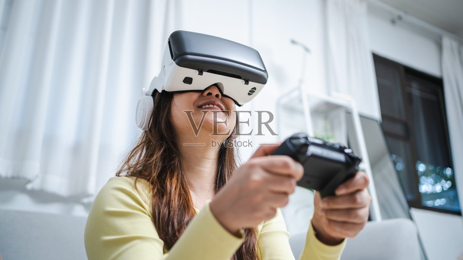 年轻的亚洲女性戴着虚拟现实触摸空气,体验未来的VR技术概念。照片摄影图片