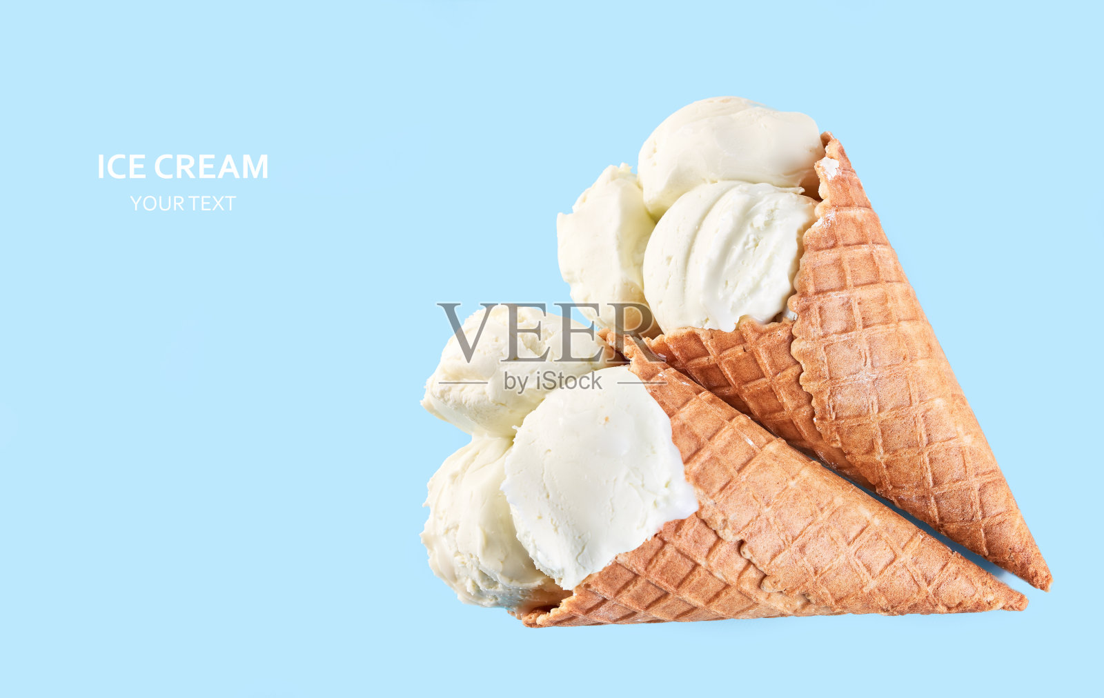 蓝色背景的华夫蛋筒里装着冰淇淋球。香草冰淇淋在华夫蛋筒里。照片摄影图片