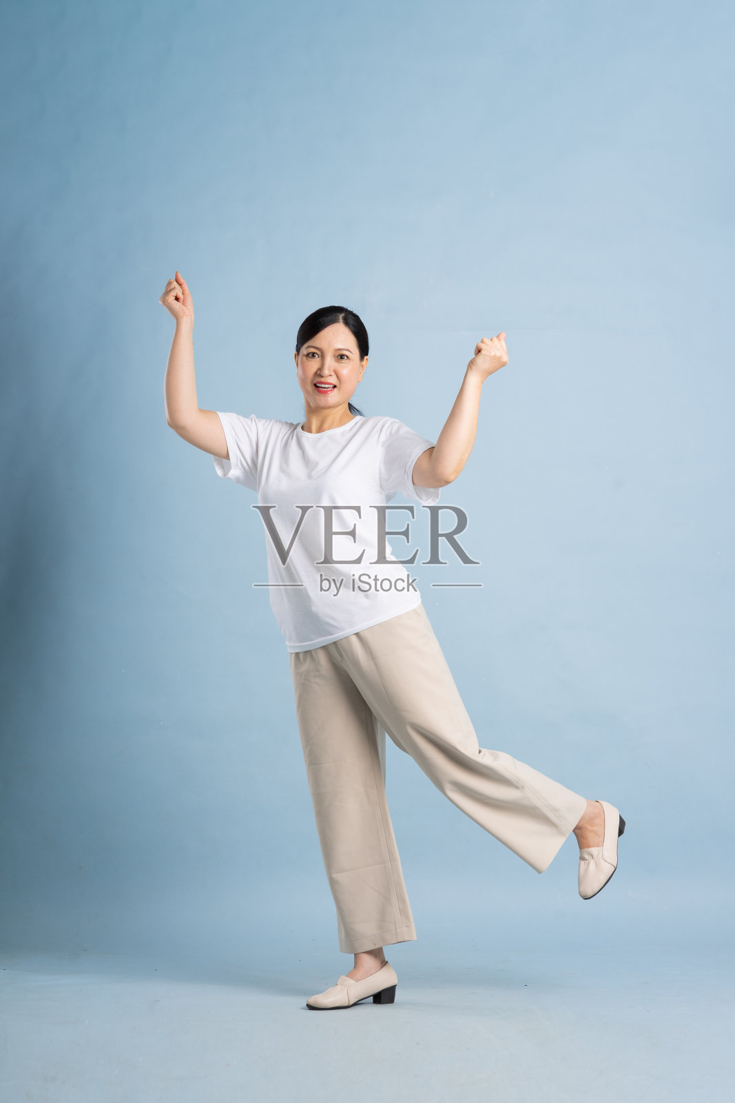 在蓝色背景下,亚洲老妇人的全身肖像照片摄影图片