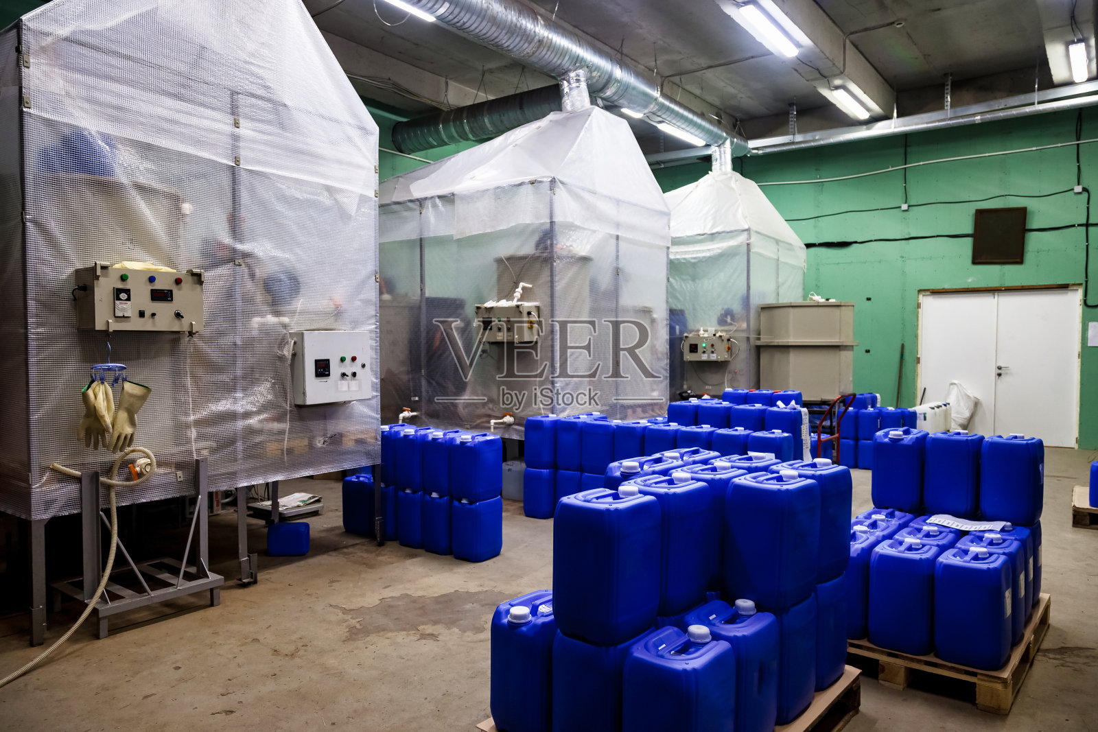 工业厂房化学仓库内部用托盘存放液体。蓝色液体容器存放在仓库中。工业仓储和货物储存的概念。复制广告文本空间照片摄影图片