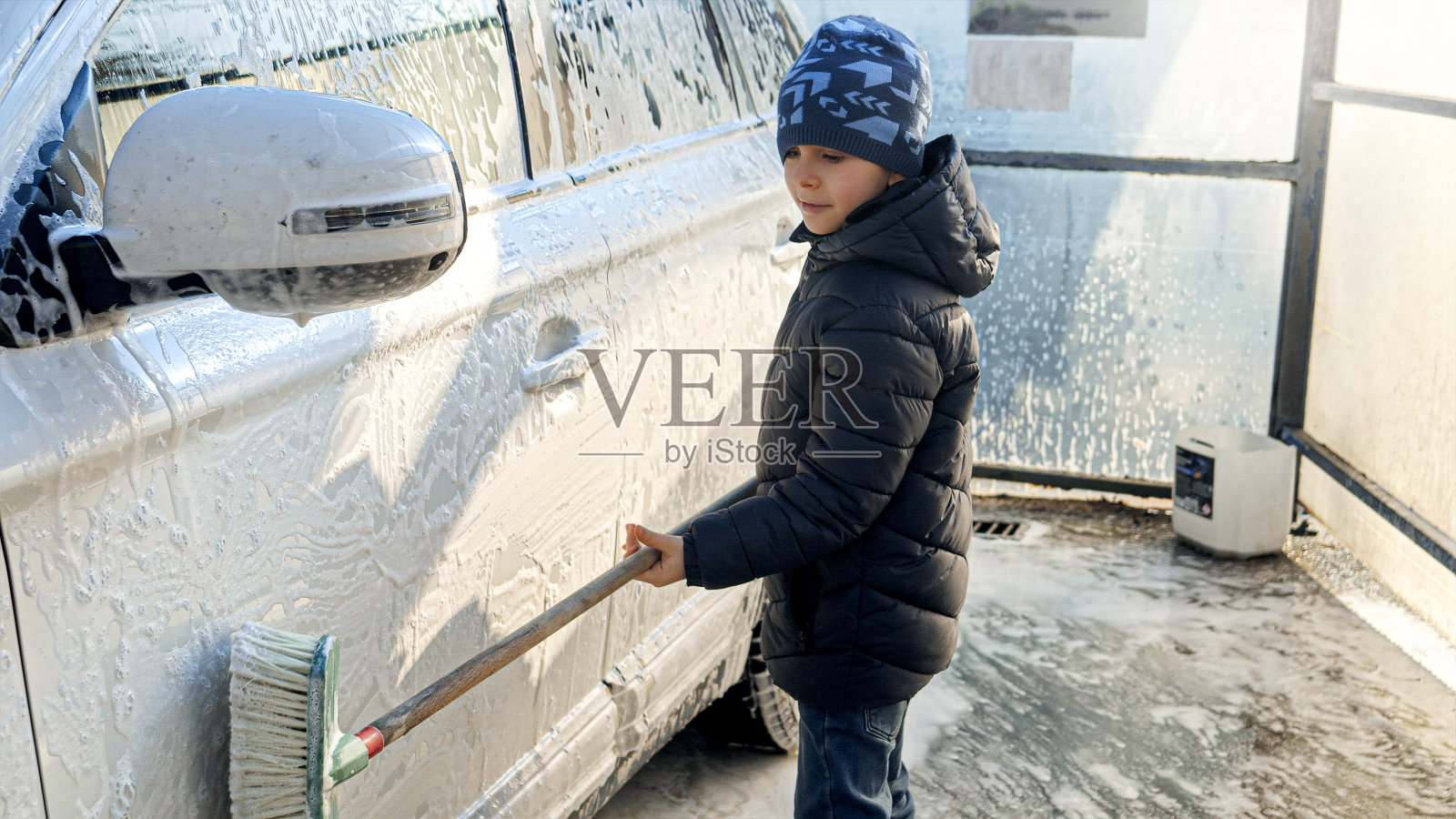 微笑的小男孩用刷子清洗和洗车在室外洗车照片摄影图片