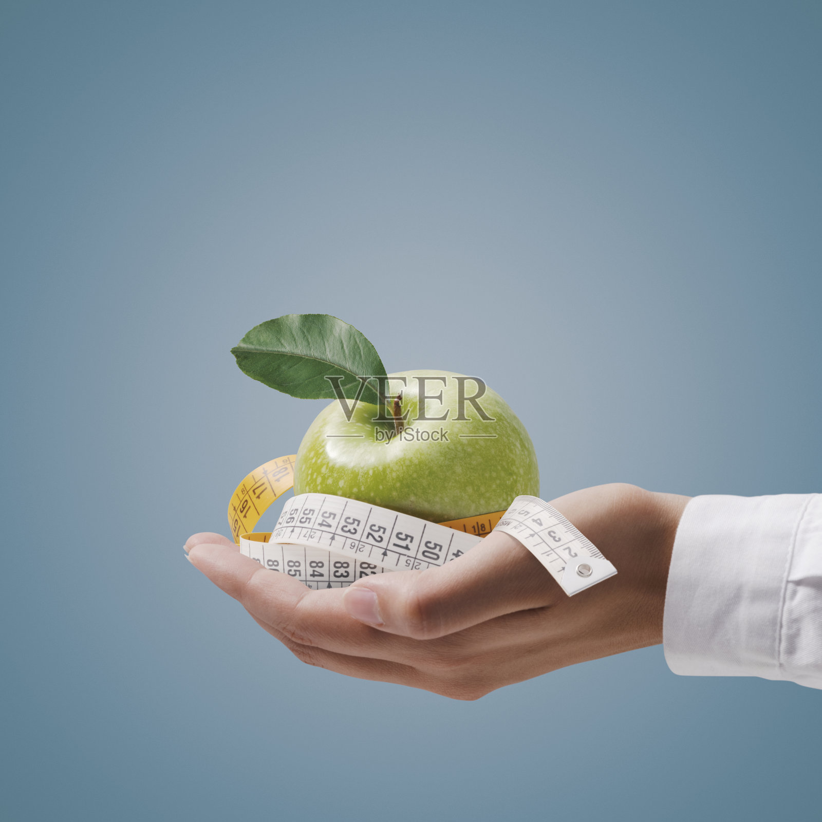 营养师拿着卷尺和苹果照片摄影图片