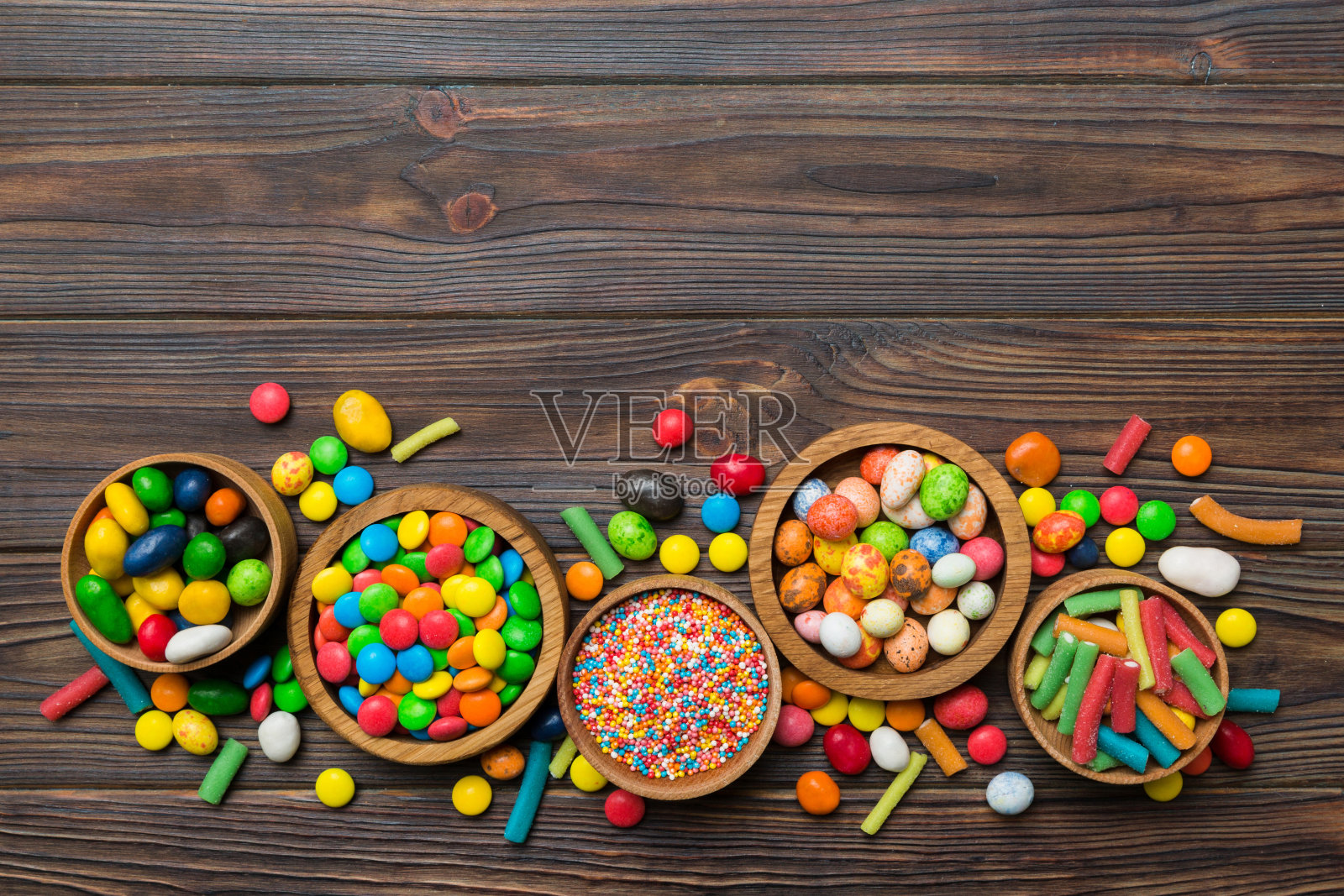 不同颜色的圆形糖果放在碗和罐子里。大品种的糖果和糖果的俯视图与复制空间照片摄影图片