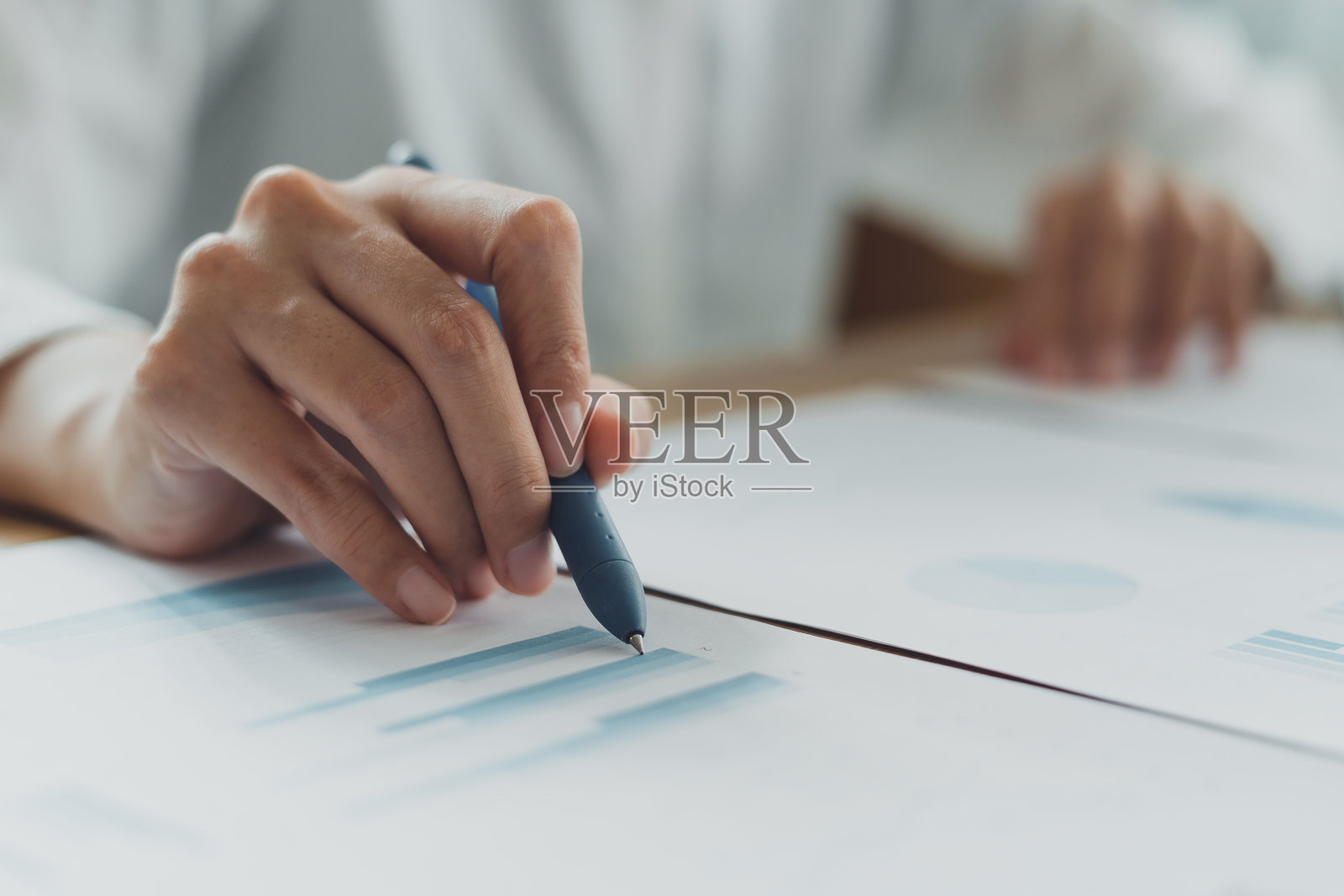 在公司办公室用笔记本电脑处理文件、报告、图表的职业女商人。笔指向数据利润文书工作。策划营销,统计分析,概念照片摄影图片