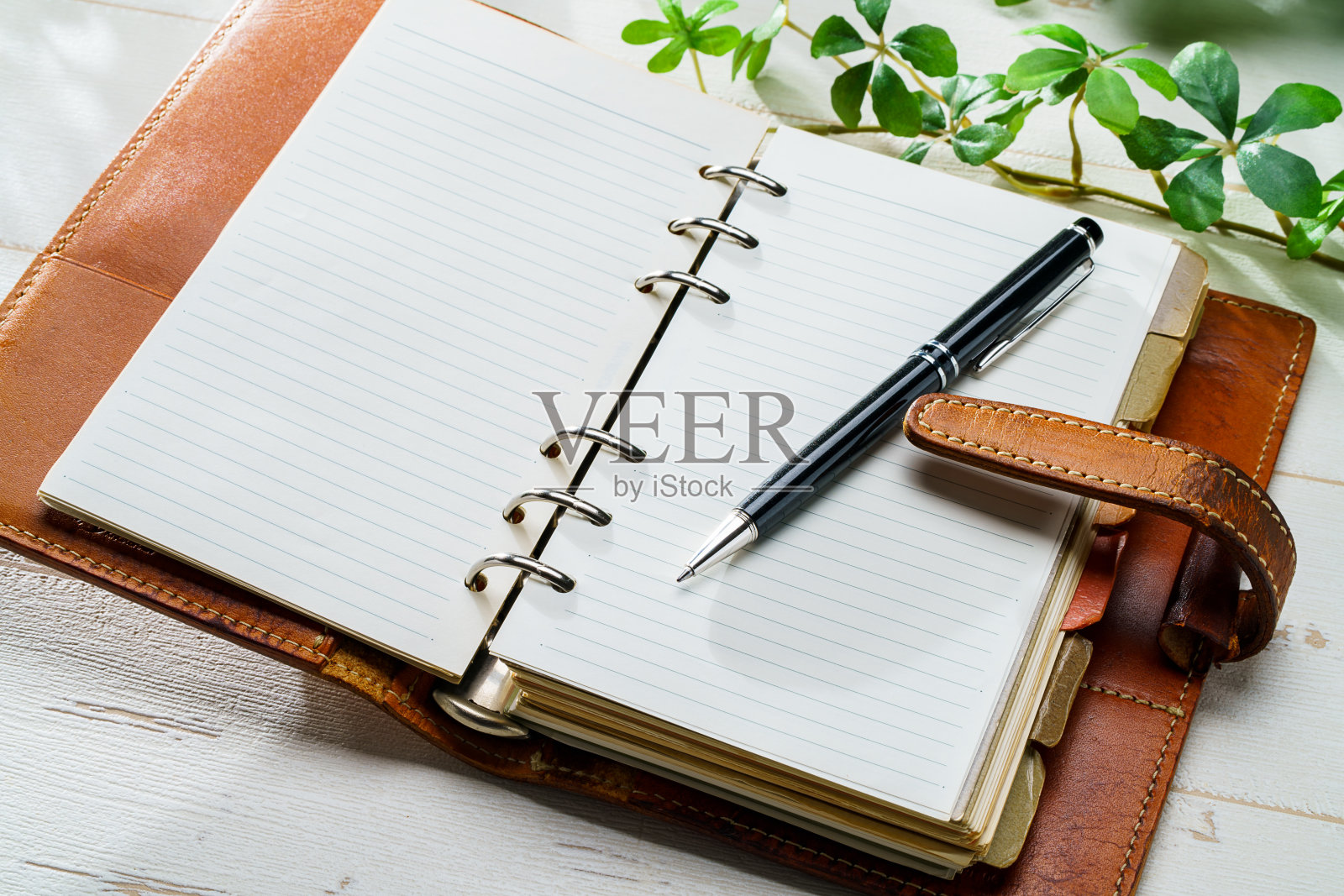 木桌上的环形记事本和笔照片摄影图片