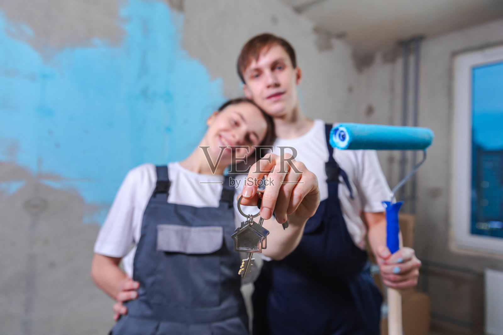 自己的家。按揭搬迁概念。幸福的夫妇拿着新房子的钥匙。一家人庆祝搬家日。买家丈夫妻子客户购买房地产持有移动箱显示钥匙。照片摄影图片