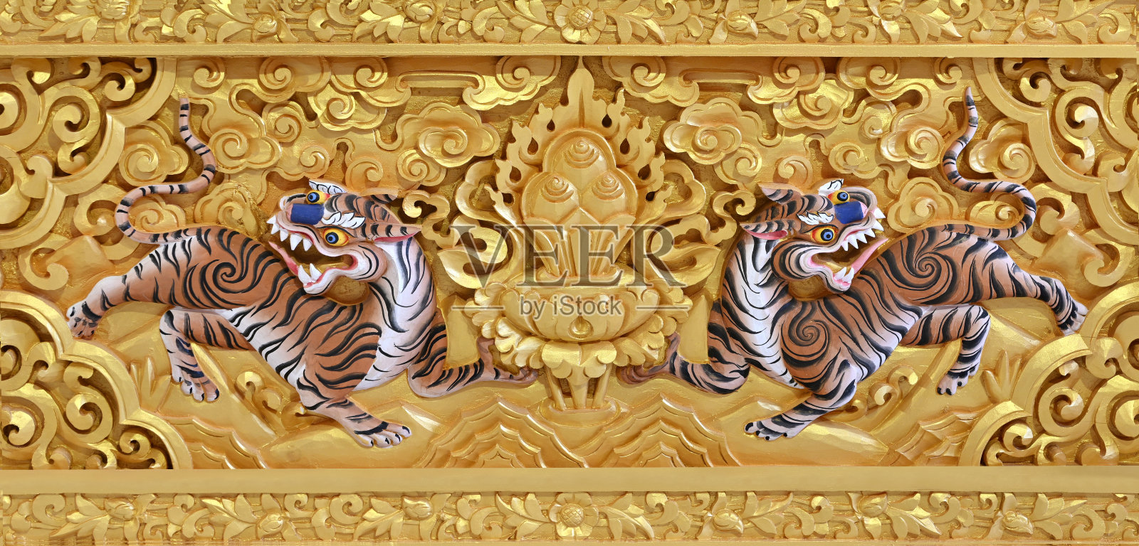 美丽的金色雕刻的神秘的老虎在圣殿佛教教堂的墙壁上照片摄影图片