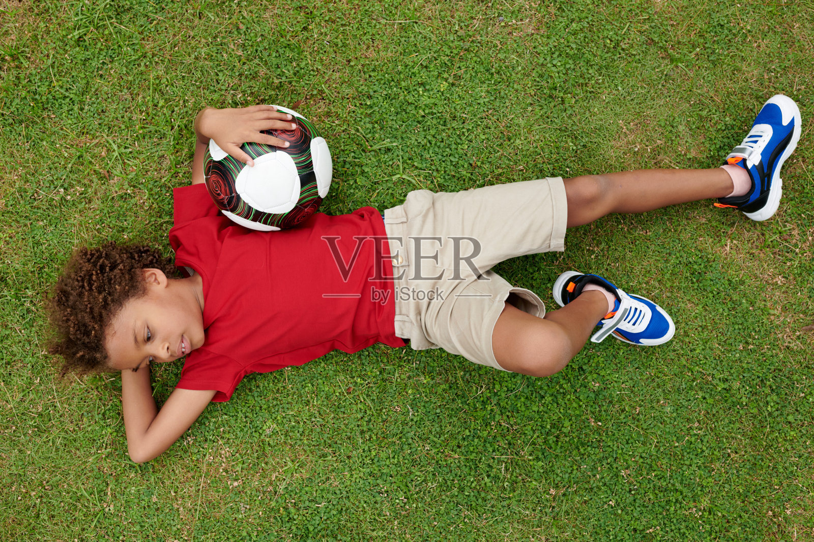 疲倦的男孩在草坪上休息照片摄影图片