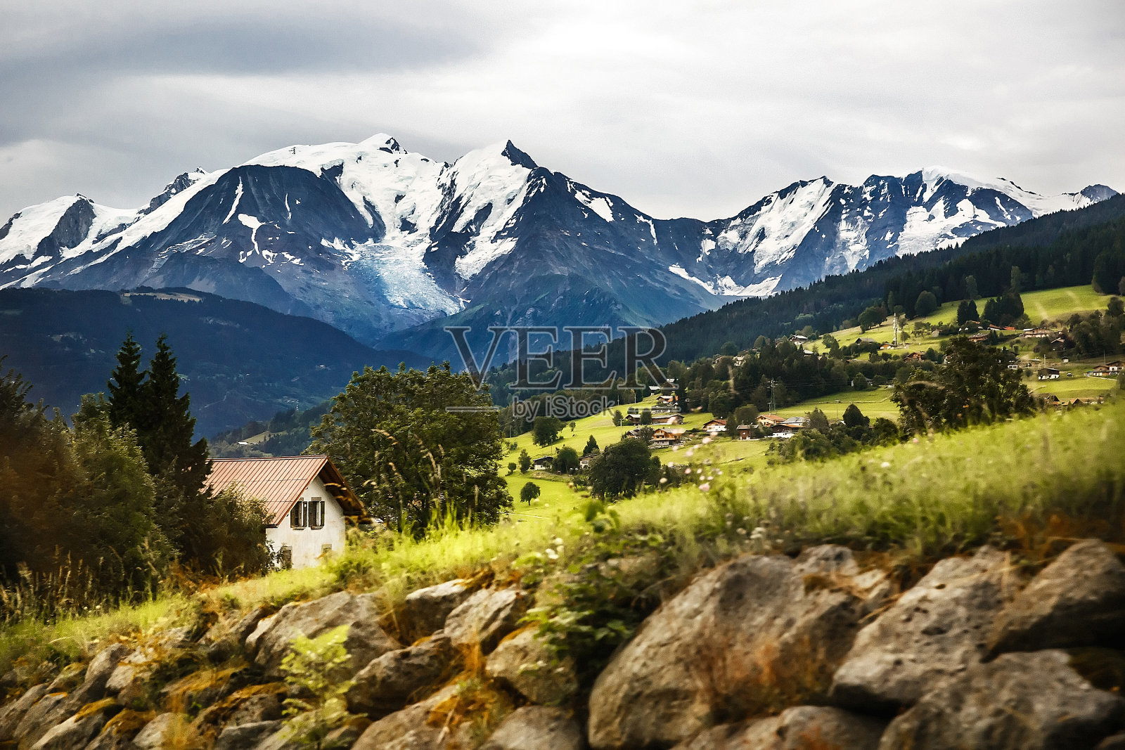 这个村庄在山里。雪山和森林照片摄影图片