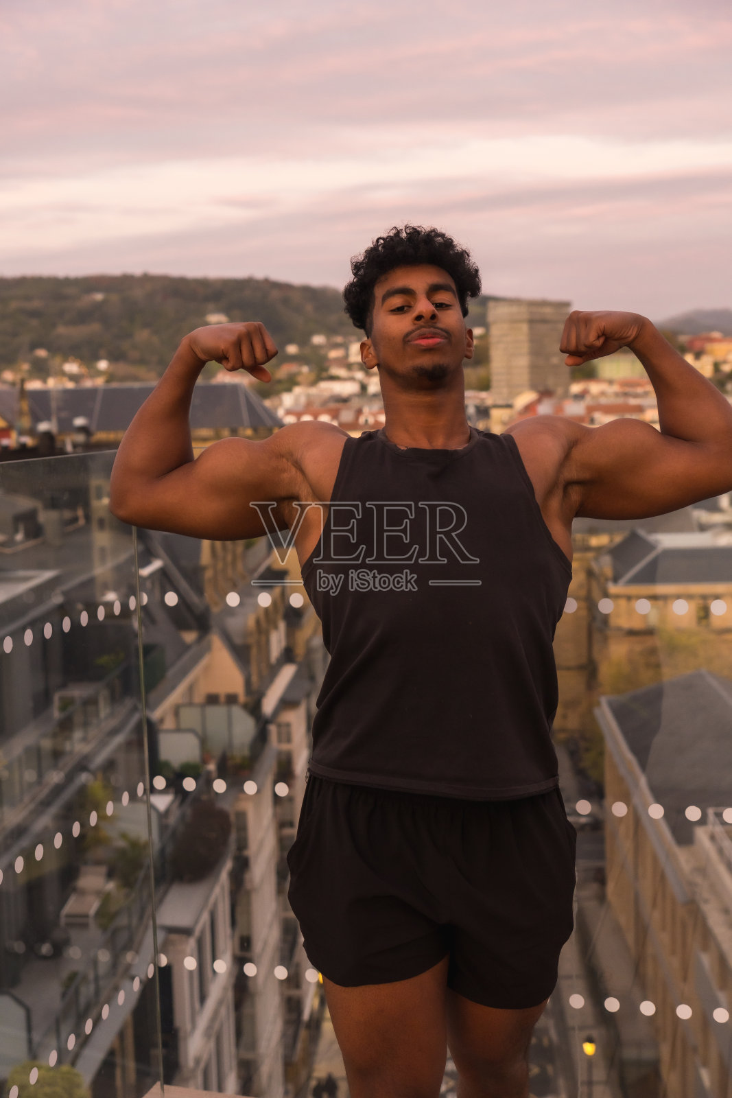 在城市里运动的阿拉伯青年,展示手臂肌肉照片摄影图片