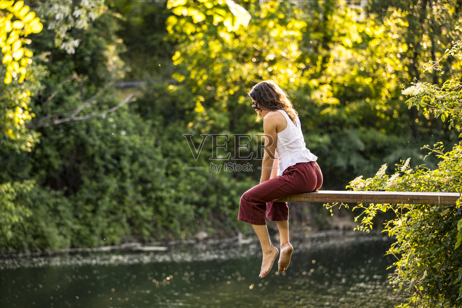 思考坐在河上跳板上的年轻女子照片摄影图片