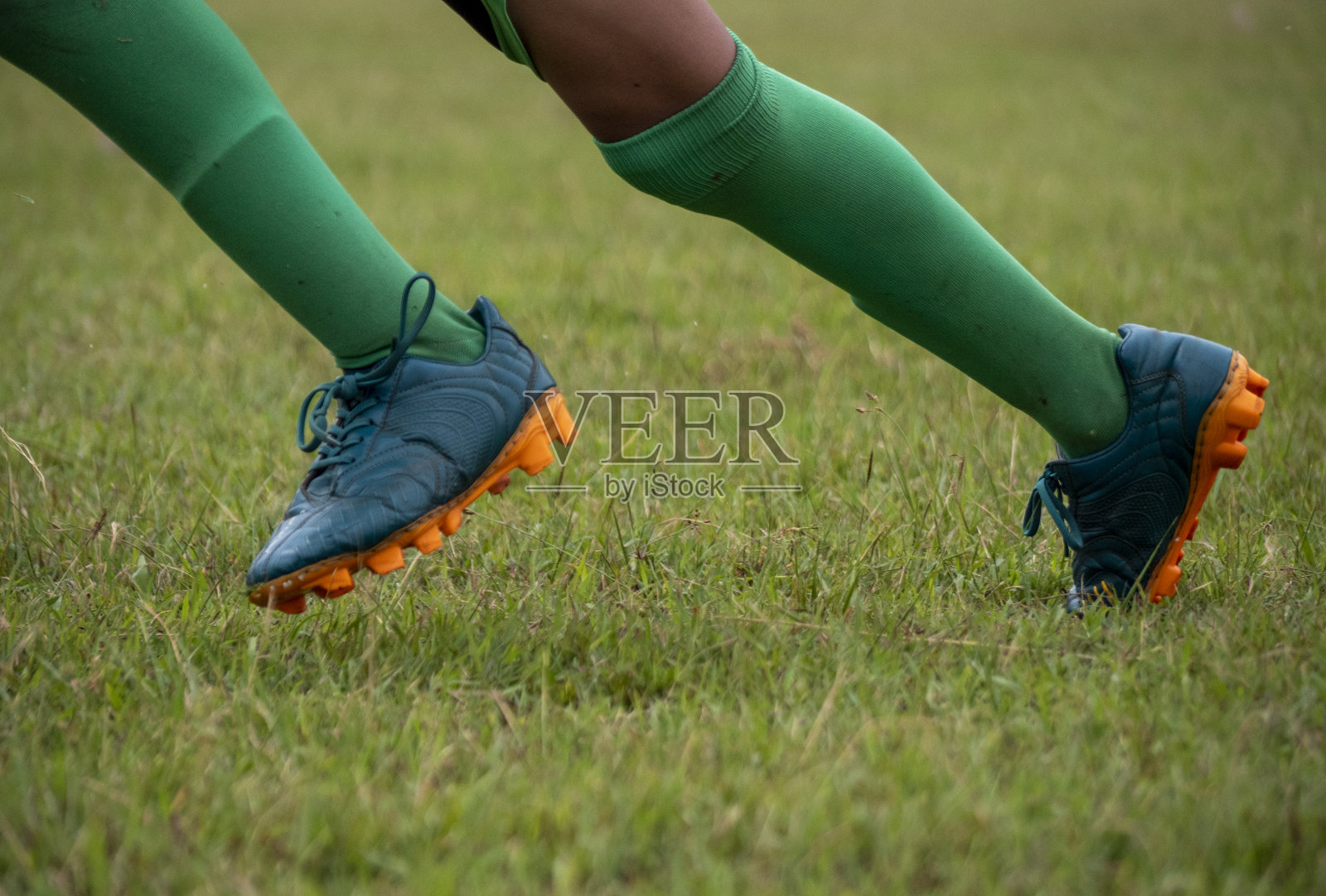 穿着足球鞋奔跑的足球运动员照片摄影图片