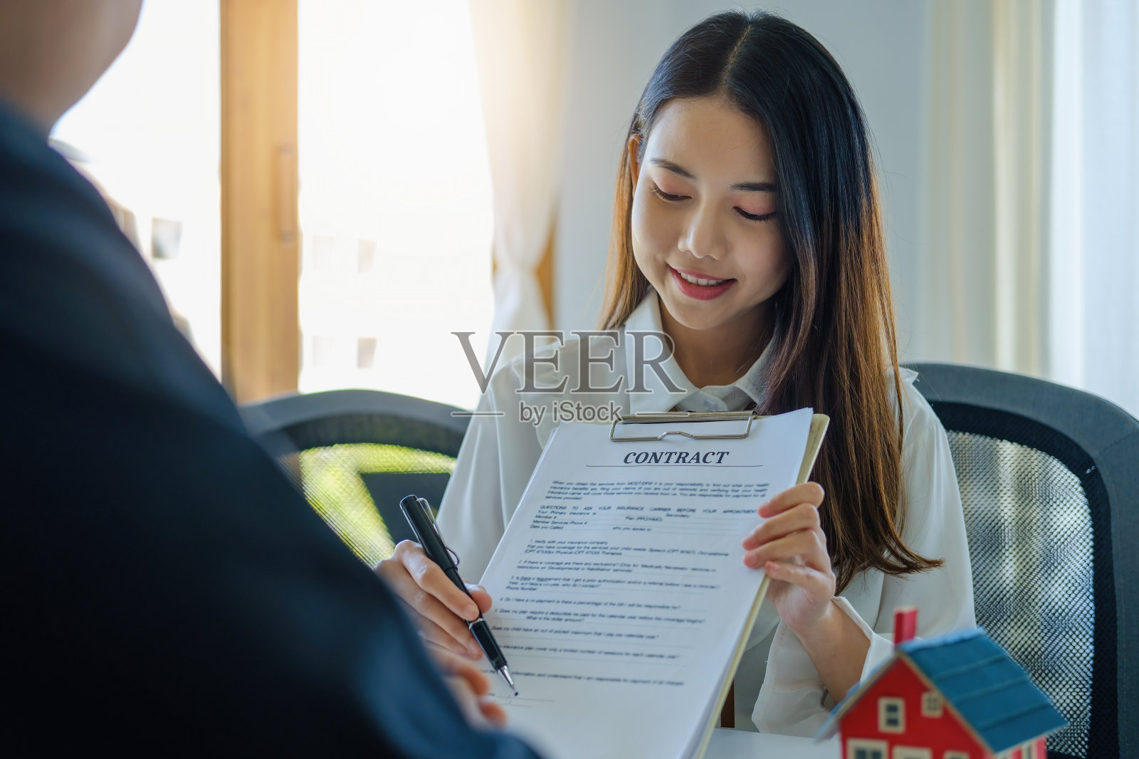 担保,抵押,协议,合同,签字,男性客户拿着笔阅读协议文件与房地产经纪人或银行职员签署土地贷款。照片摄影图片