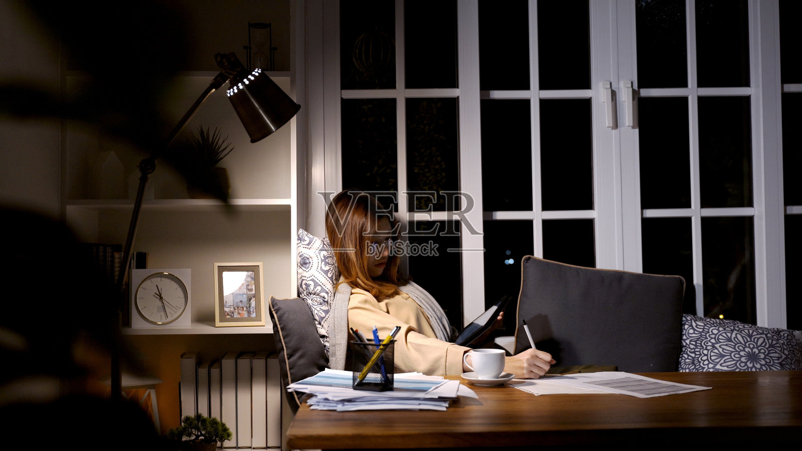 亚洲女商人晚上在线工作。在家加班,忙得精疲力竭照片摄影图片