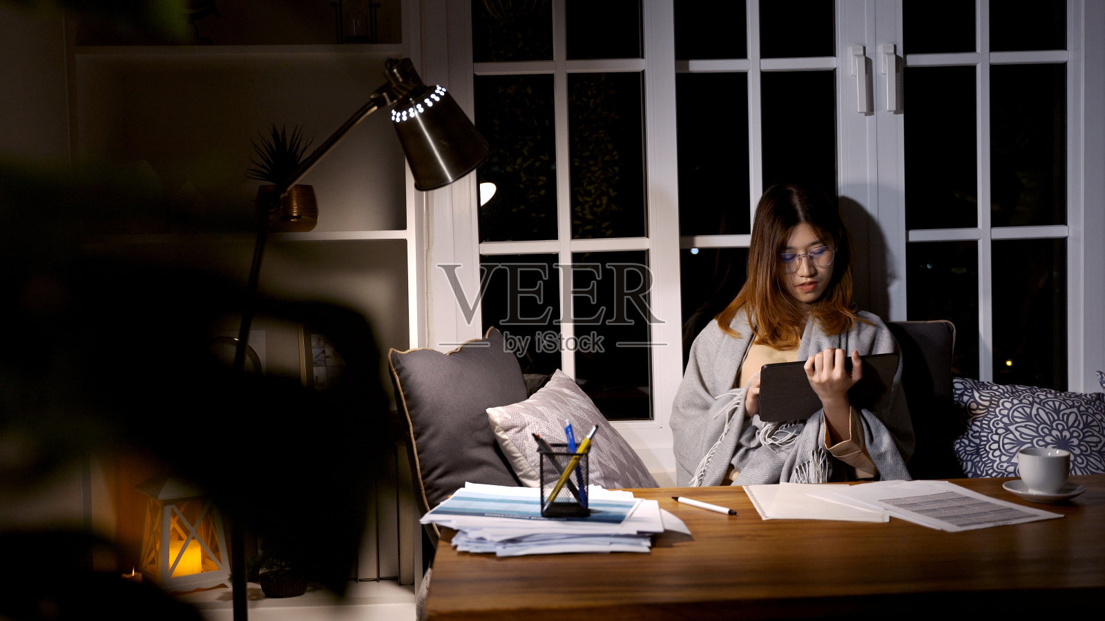 亚洲女商人晚上在线工作。在家加班,忙得精疲力尽照片摄影图片