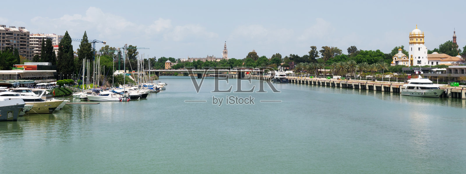 瓜达尔基维尔河,背景是安达卢西亚塞维利亚的圣塔大教堂María de la Sede y de la Asunción。西班牙。欧洲。2022年5月1日照片摄影图片