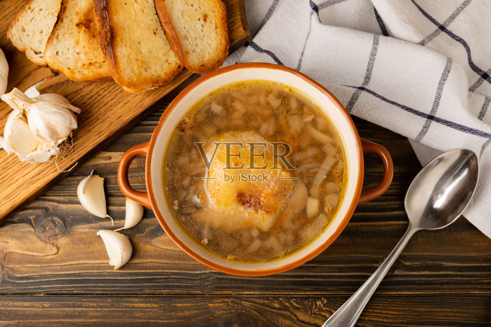 木桌上有胡萝卜、土豆和鸡肉的荞麦汤。健康食品。有面包丁、大蒜和香料的汤。副本的空间。照片摄影图片