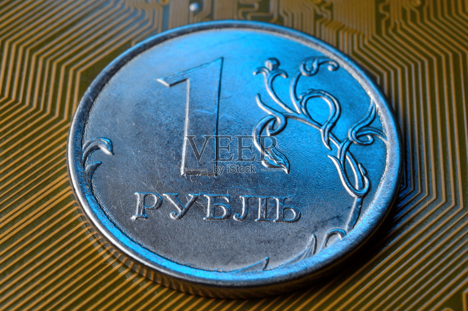 一枚面值为1卢布的硬币放在一个微电路上。特写镜头。硬币上的铭文翻译:“1卢布”俄罗斯联邦数字经济的概念。照片摄影图片