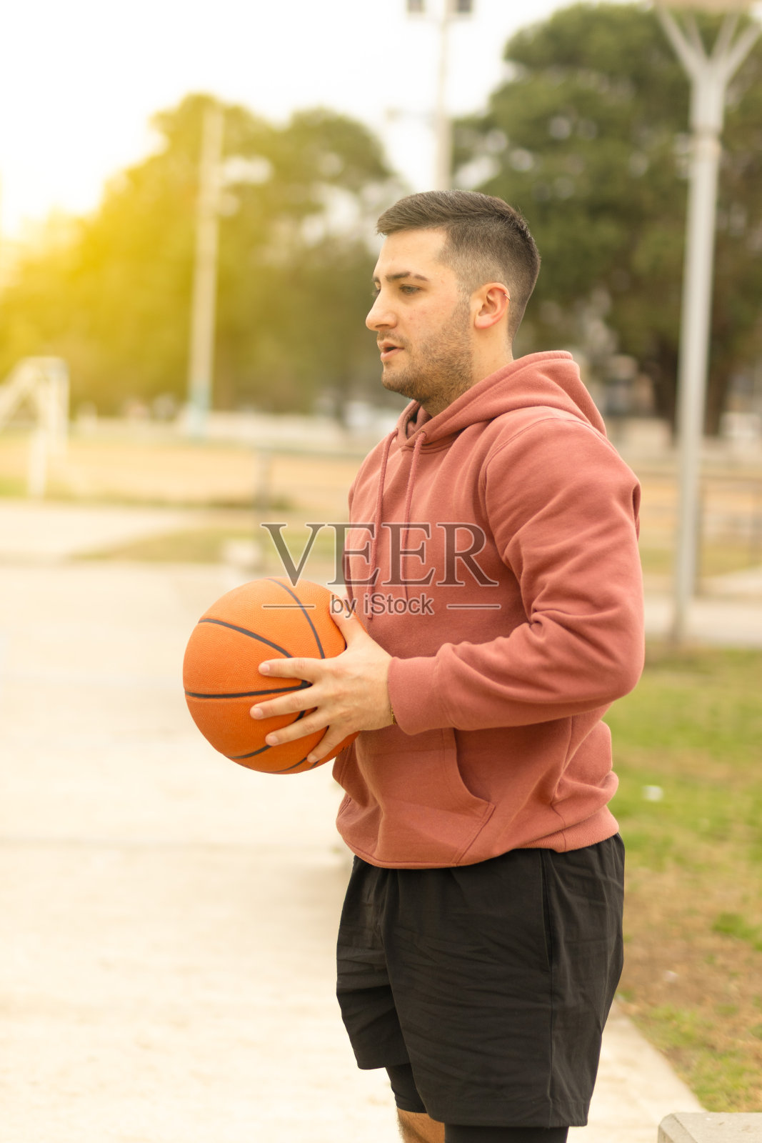 一个穿着运动衫,手里拿着篮球的年轻人。集中精力玩游戏。体育概念,运动员,竞争照片摄影图片