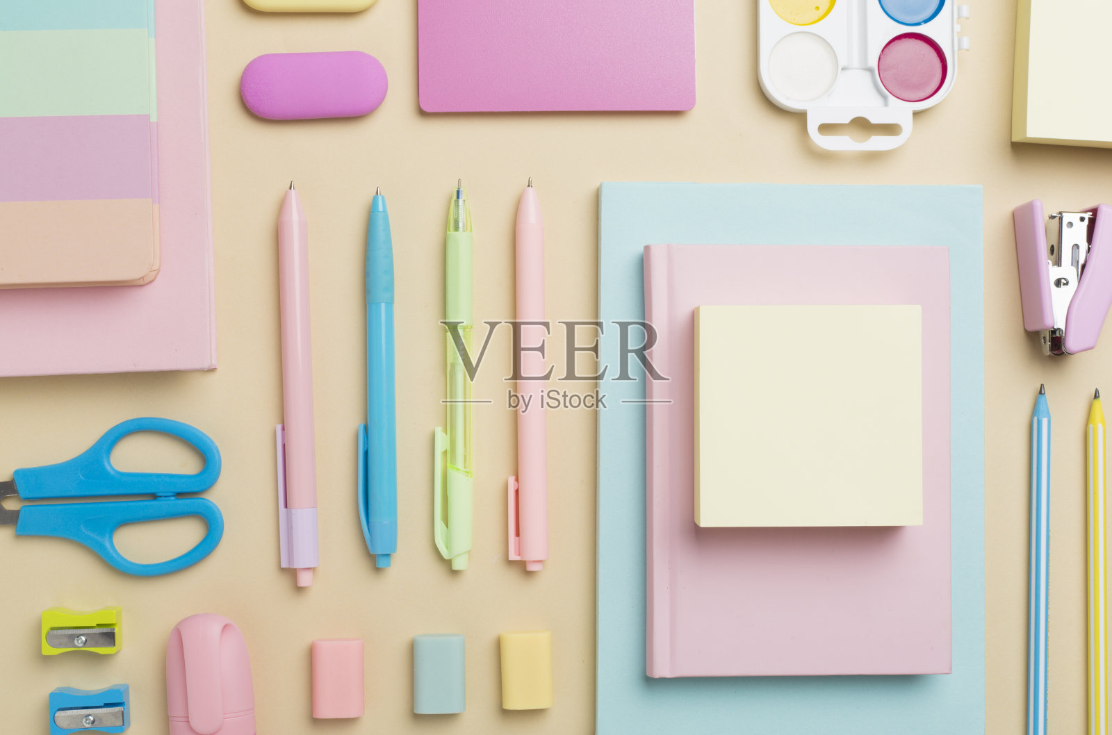 彩色背景上平铺着五颜六色的学校文具,俯视图照片摄影图片