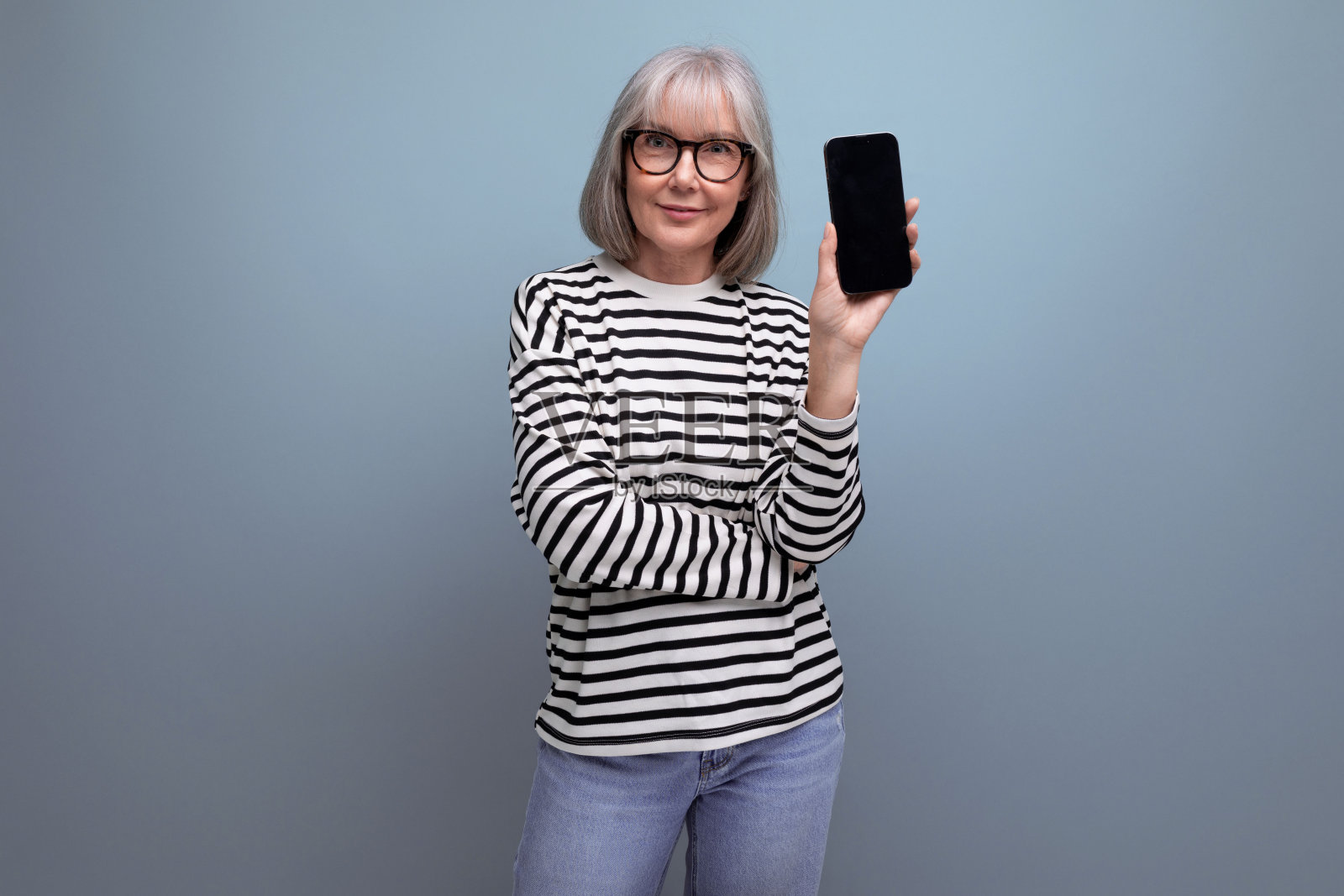 衣着整洁修长的60多岁中年妇女拿着智能手机,在明亮的背景上有复制空间的模型照片摄影图片
