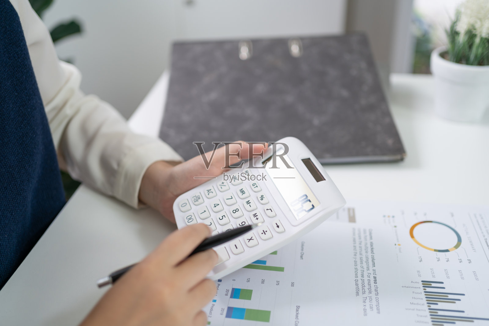 女商人会计分析投资图表,发票和按计算器按钮的文件。会计簿记员ClerkÂ银行顾问和审计师的概念照片摄影图片