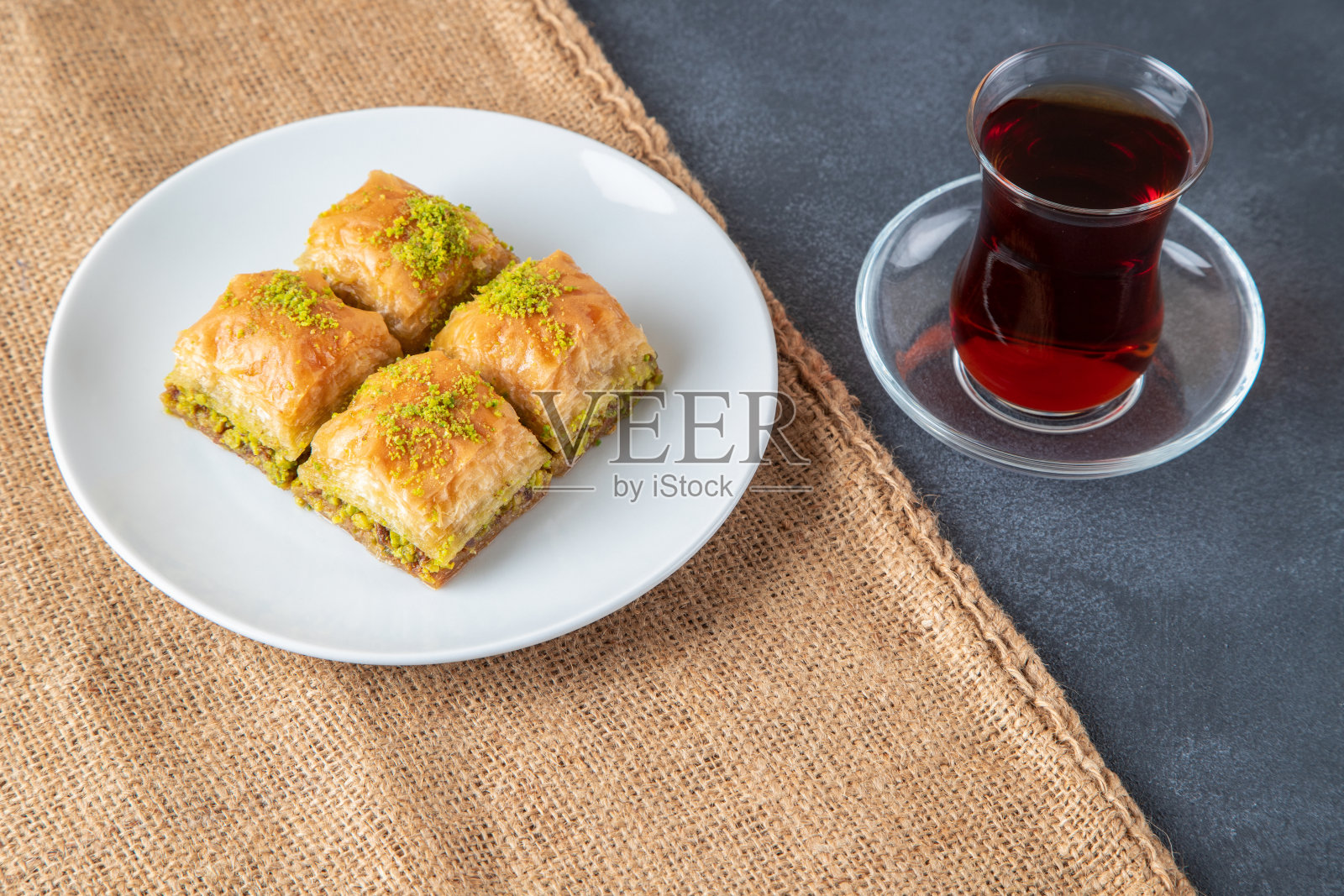 开心果果仁蜜饼放在白色盘子里,配土耳其茶照片摄影图片