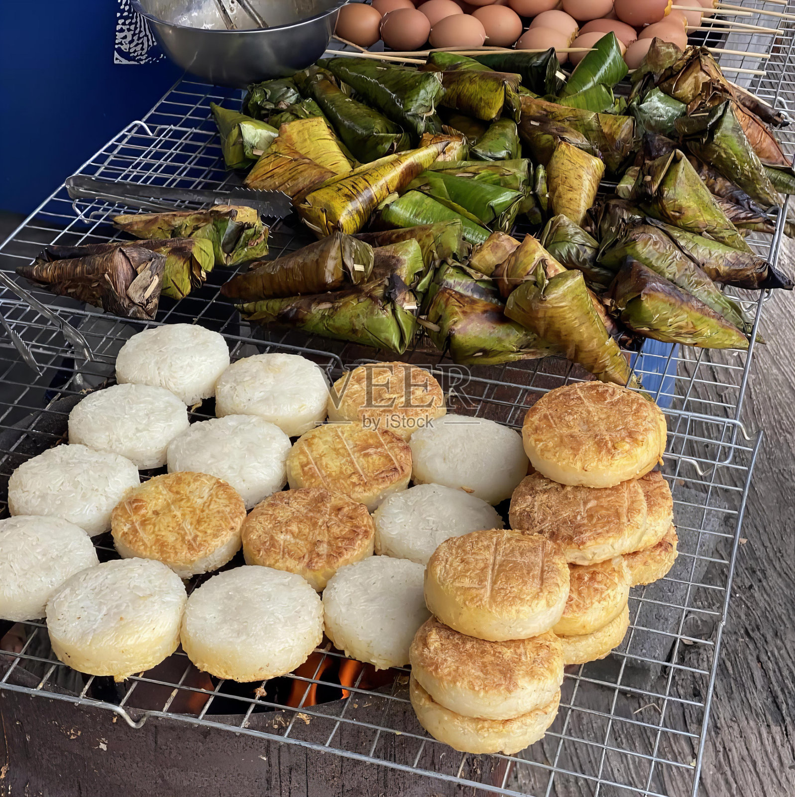 一张桌子上放着一堆食物的照片,烤屋的食物放在铁丝架上,上面放着鸡蛋和其他食物。照片摄影图片