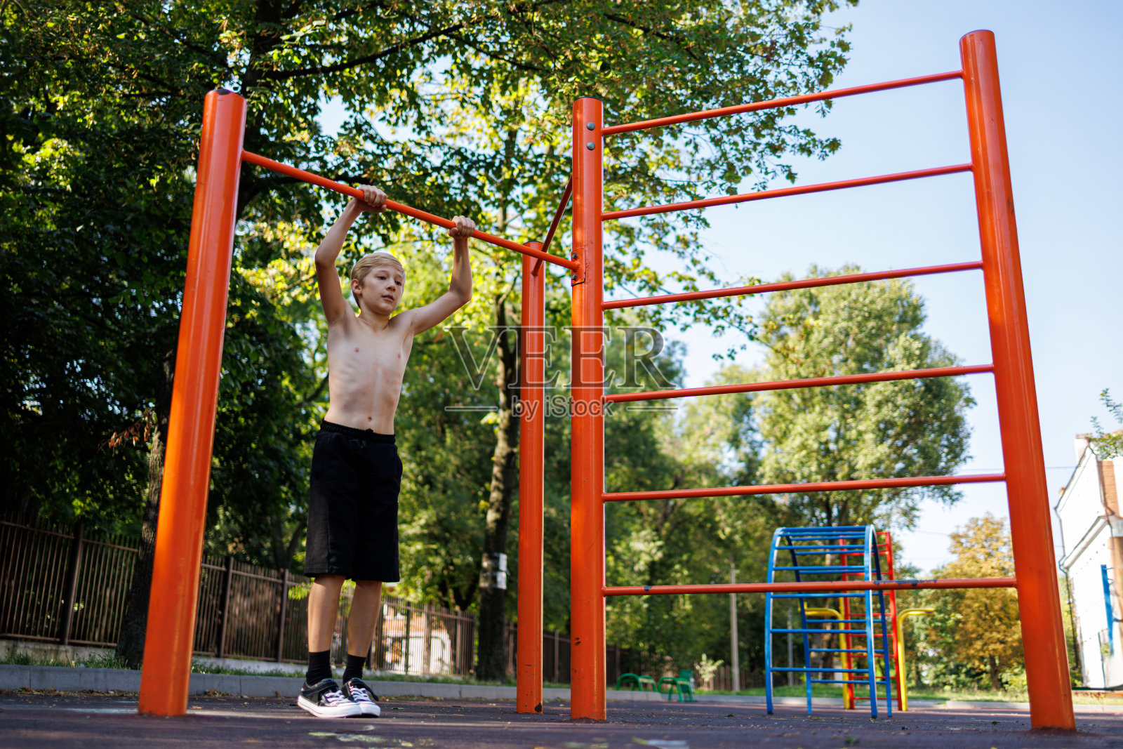 在学校公园的单杠上进行街头锻炼。照片摄影图片