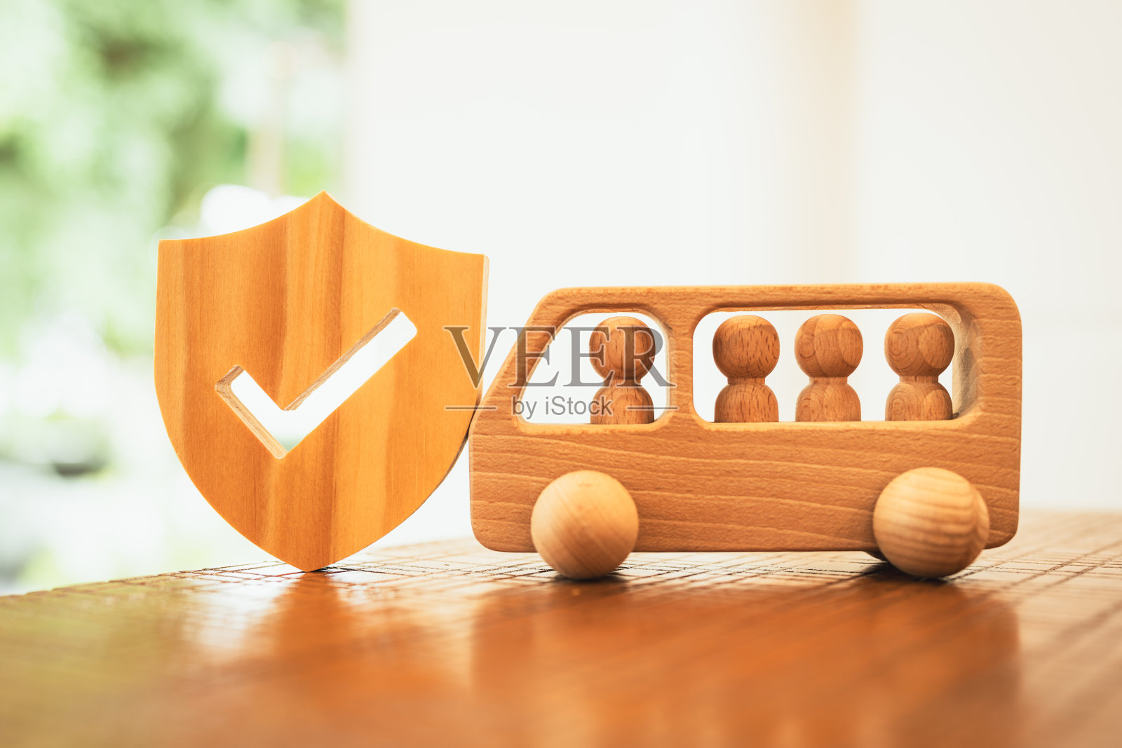 盾牌标志和木车,上面有很多人,概念为团体保险和保护。照片摄影图片