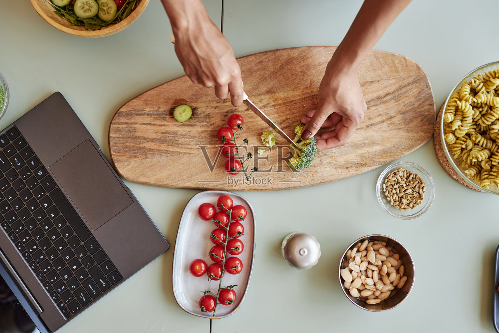 俯视图年轻女子切圣女果和花椰菜照片摄影图片