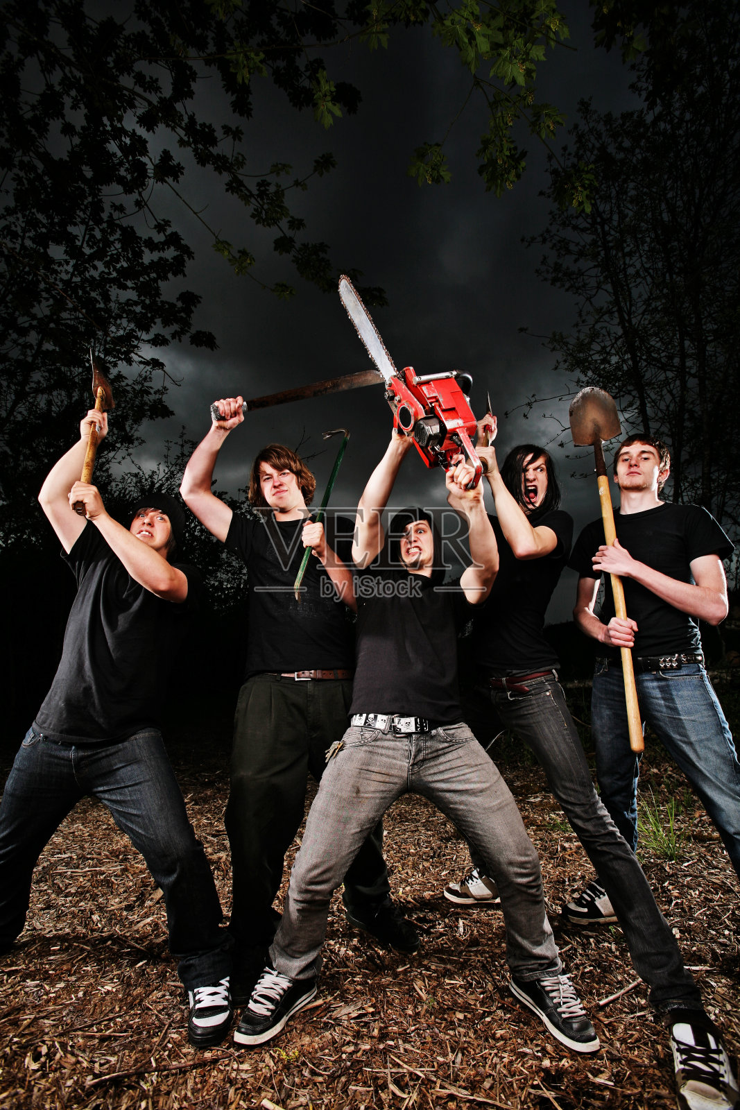 五个人在黑暗的天空下挥舞着工具照片摄影图片