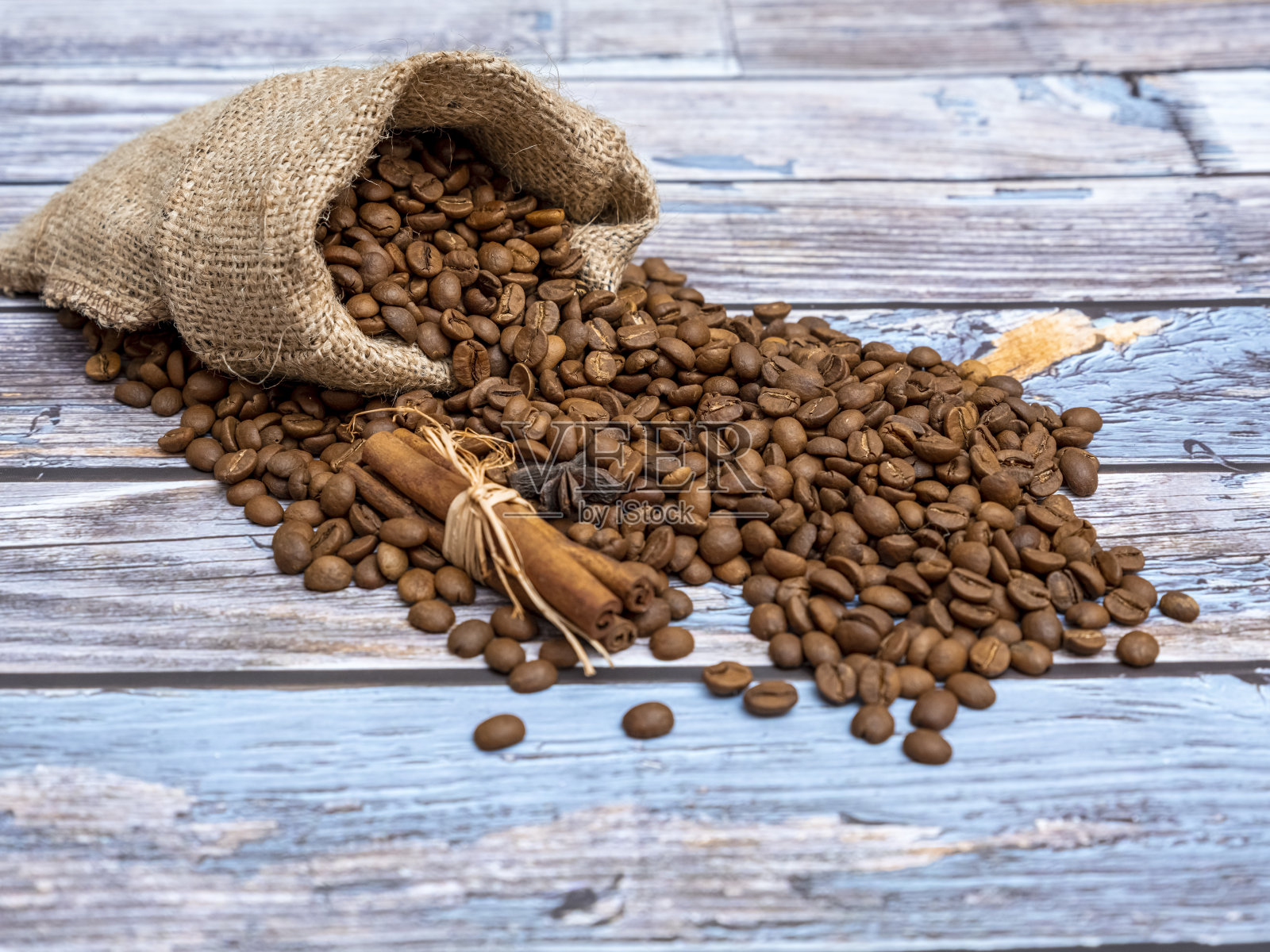 咖啡豆从袋子里洒出,洒在木地板上照片摄影图片