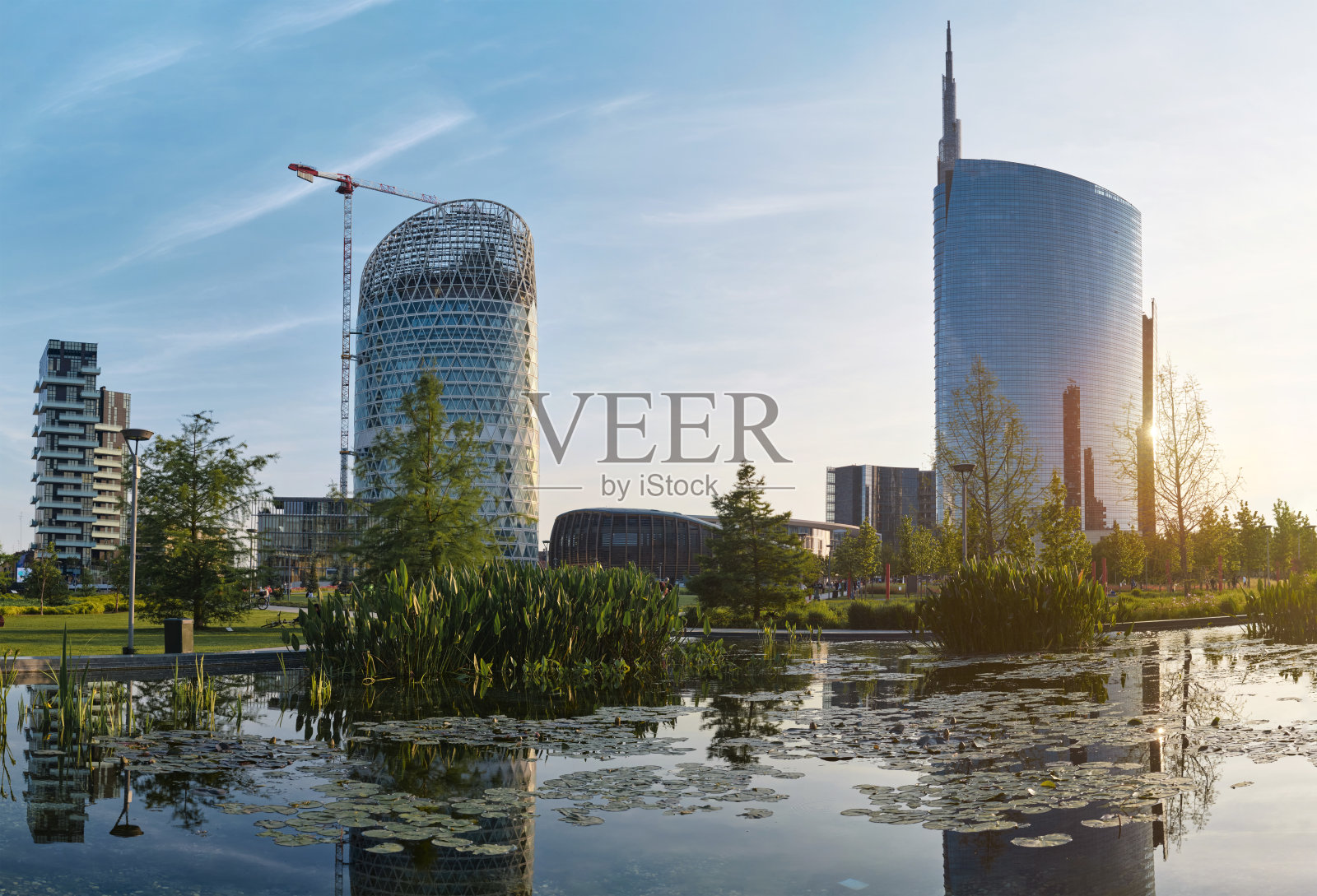 米兰新商业区的现代建筑、人工湖和花园。照片摄影图片