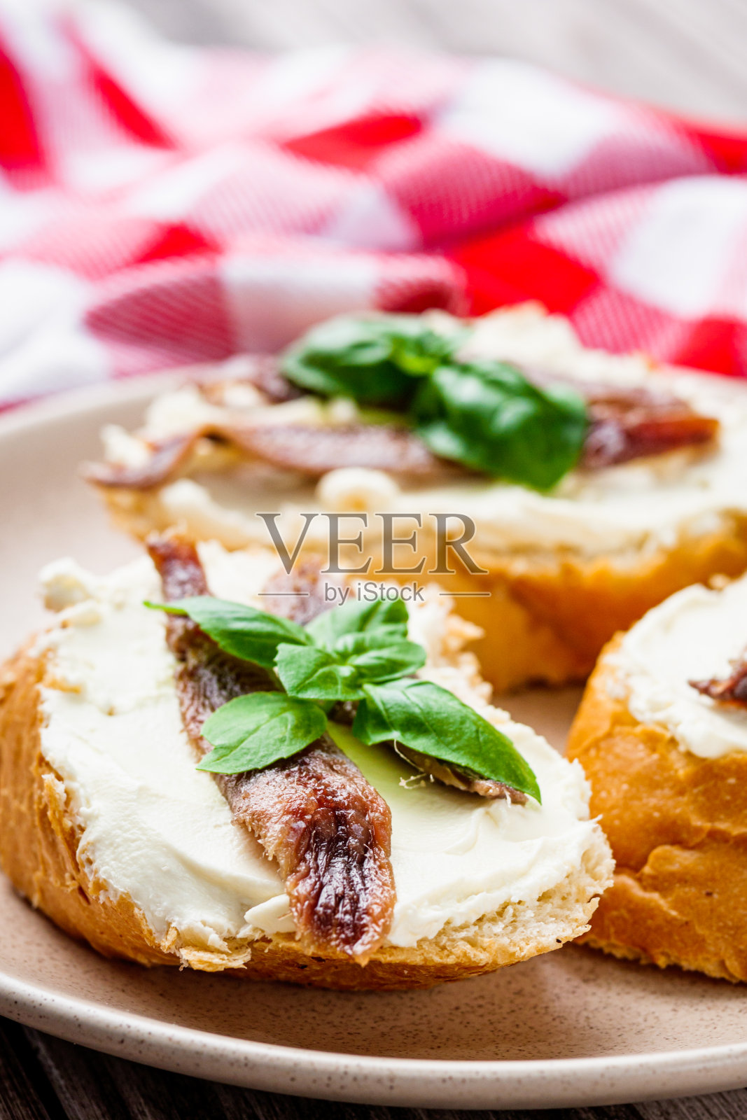 三明治与凤尾鱼鱼片托盘上服务在一个木制质朴的背景照片摄影图片