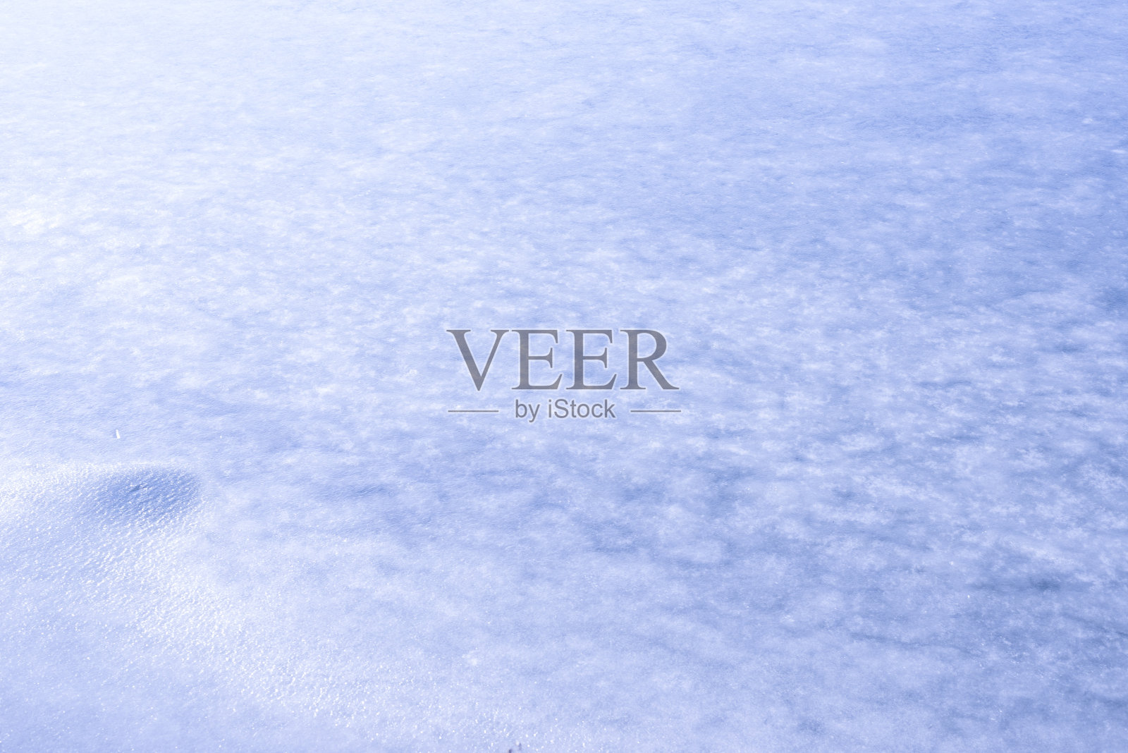 冰的自然纹理,以冰冻的湖泊为背景。照片摄影图片