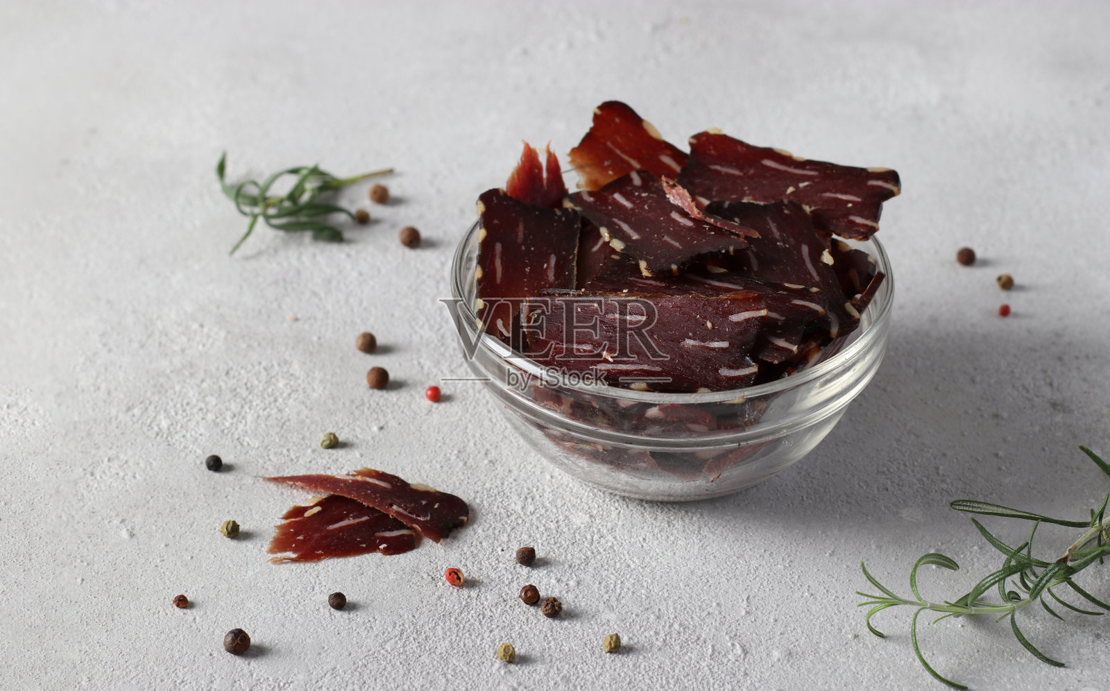 碗与肉干,辣椒和迷迭香浅灰色的背景。水平格式照片摄影图片