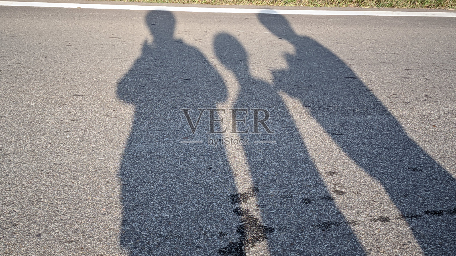 耀眼的阳光在铺砌的路面上形成了人的影子的反射照片摄影图片