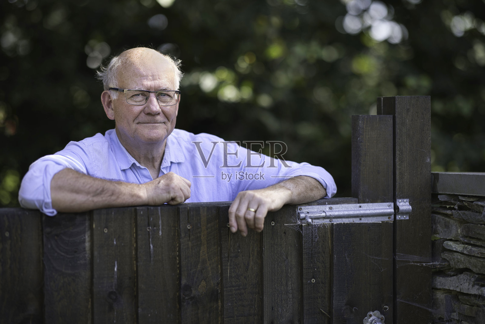 一位老人站在花园门口照片摄影图片