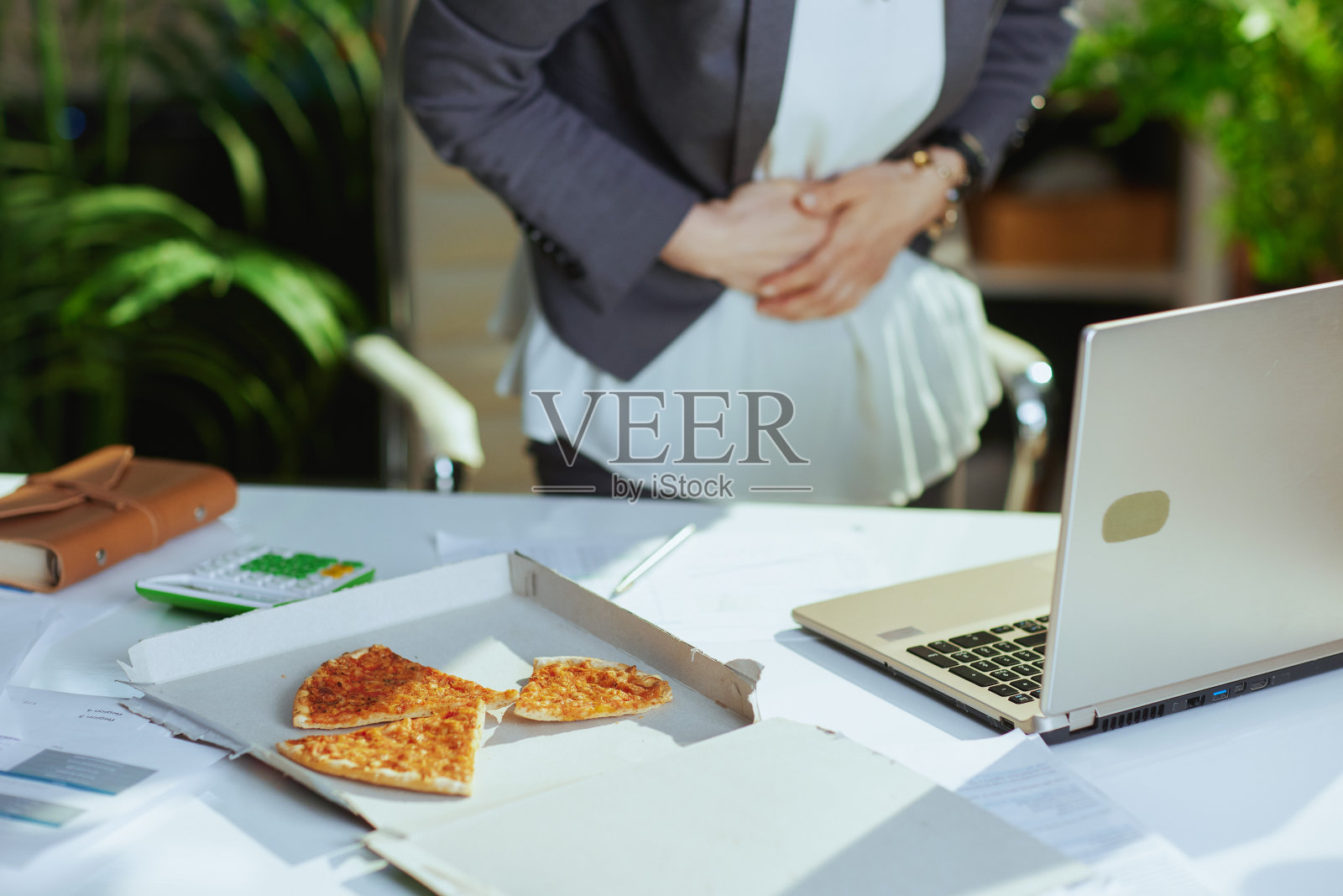 绿色办公室的现代女工胃痛照片摄影图片